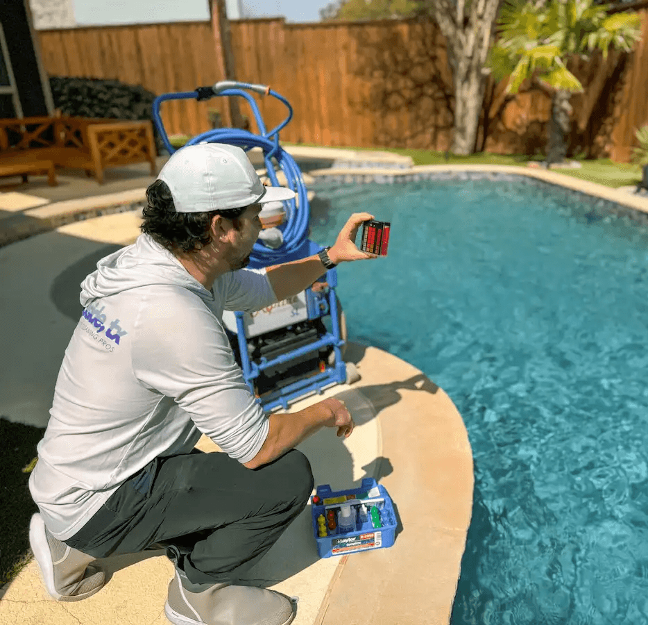 Poolside, TX certified pool professional checking pool chemical balance in yard of Plano, TX homeowner