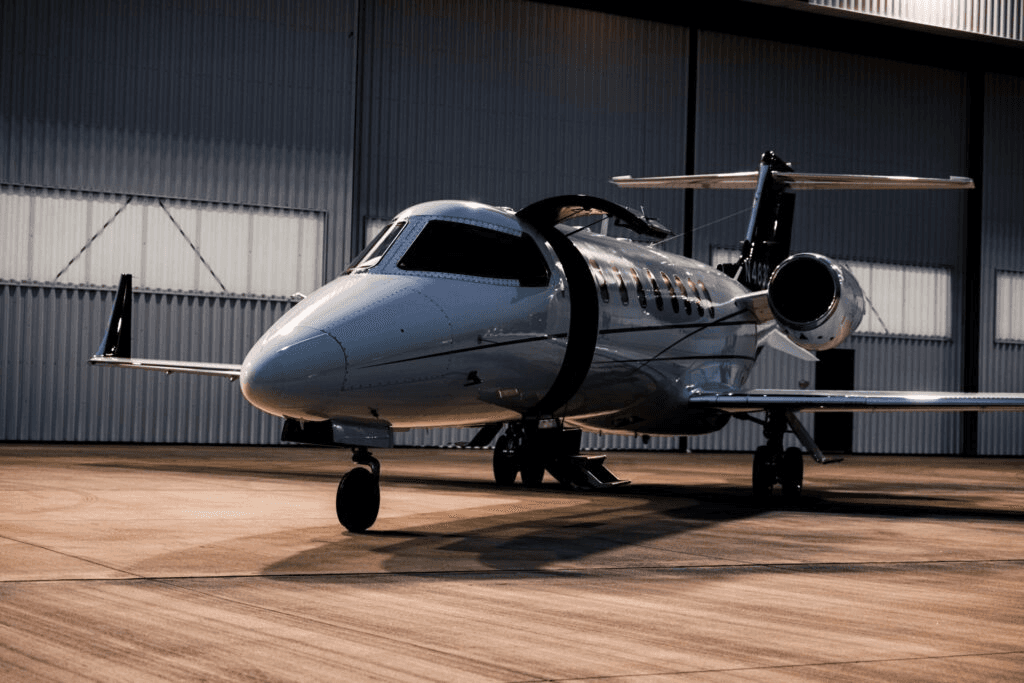 white jet near hanger with open door