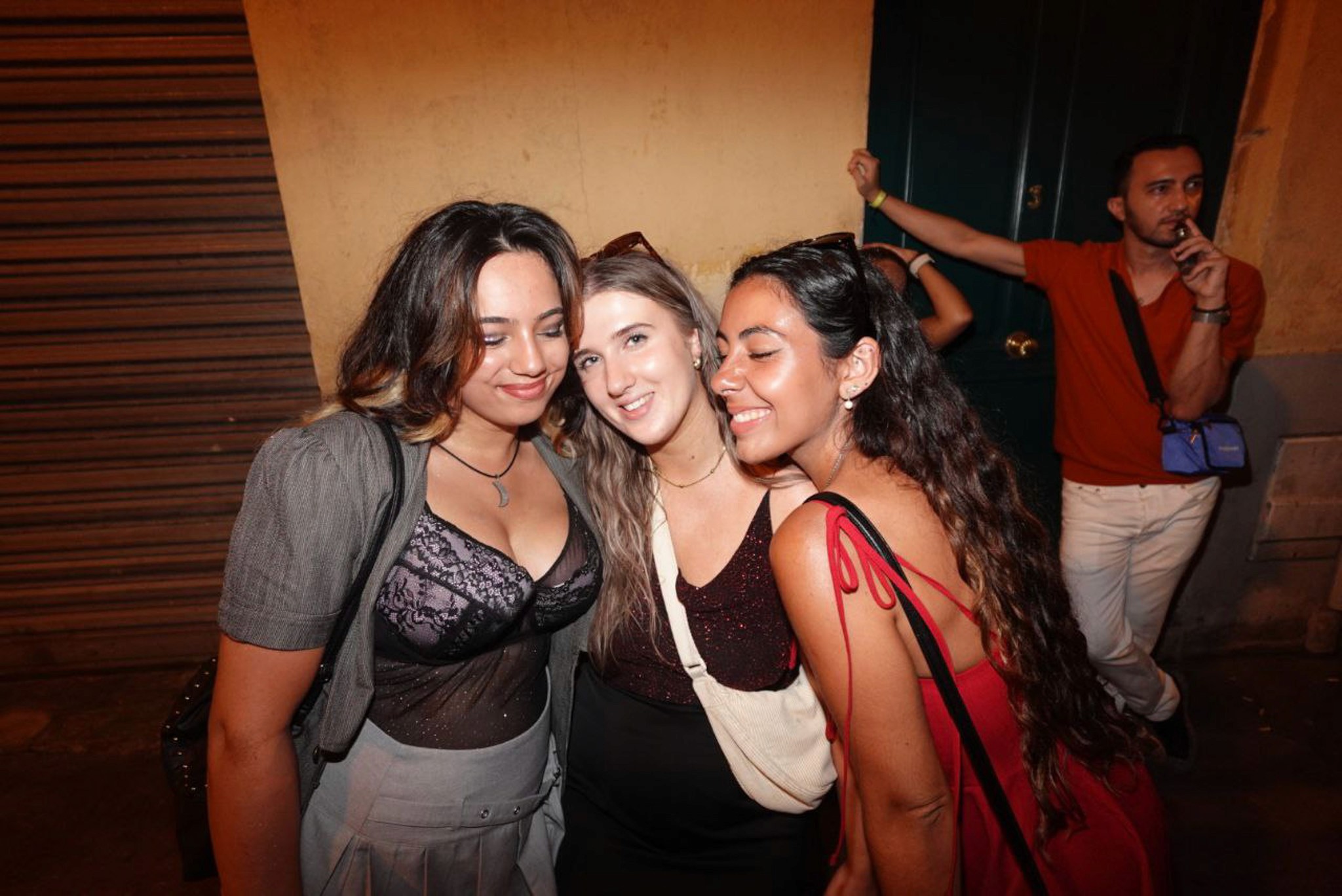 A solo traveler enjoying nightlife in Nice, walking confidently through lively streets with bars and cafés illuminated at night.