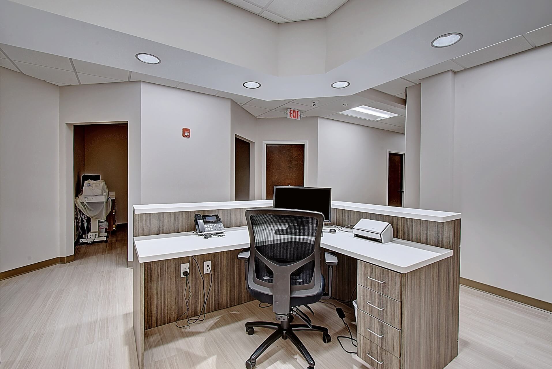 A modern office space featuring a desk, ergonomic chair, computer, and minimalistic decor.