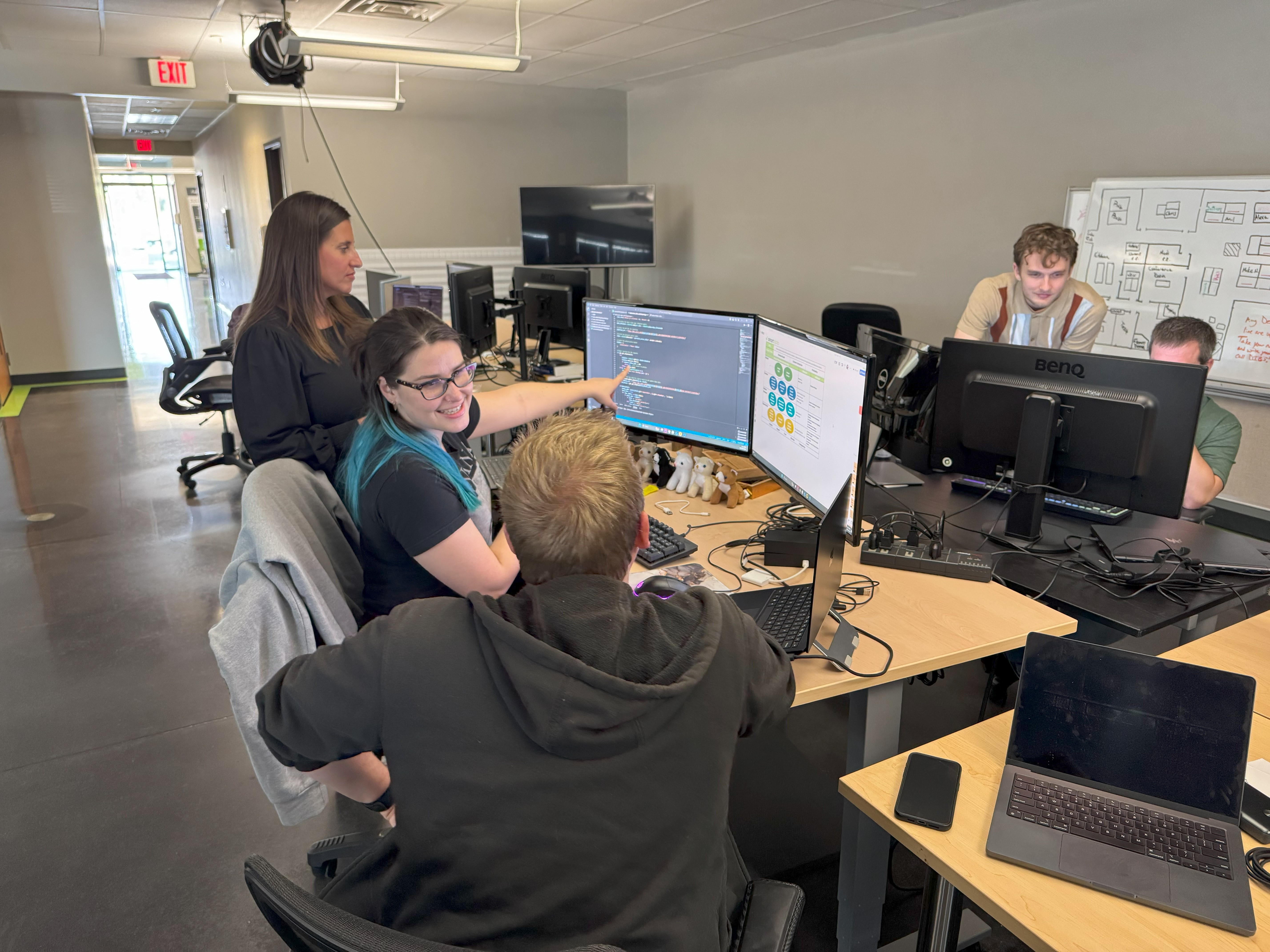 A group of Smart Data Employeesworking at computer desks in a modern office environment.