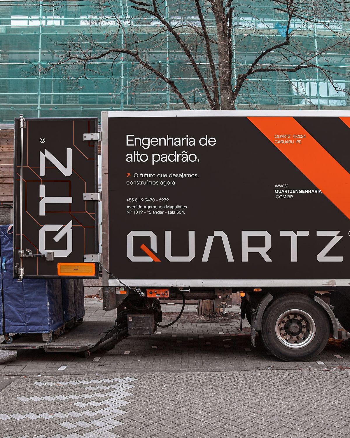 Two colleagues collaborating over paperwork at an office desk, with plants in the background.