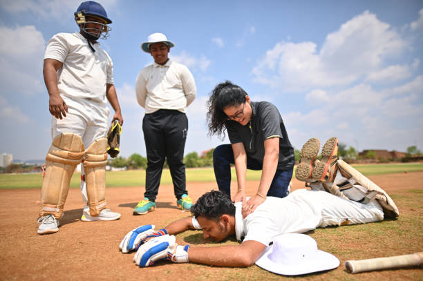 Sports physiotherapist treating a cricketer with on-field back pain management techniques.