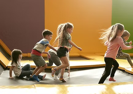 Kinder spielen gemeinsam auf einer Hüpfmatte – Projektförderung der Arche Kinderstiftung durch die DAG Gruppe.