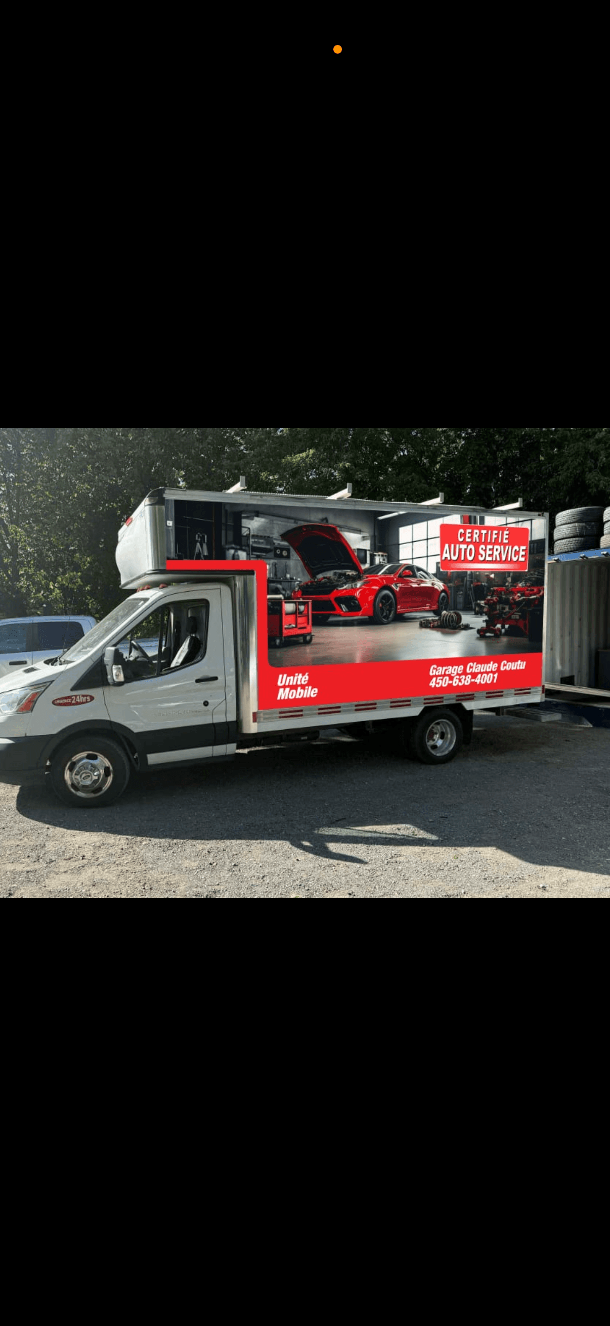 Voiture d’occasion à vendre devant le garage Claude Coutu, avec les portes ouvertes sur l’atelier