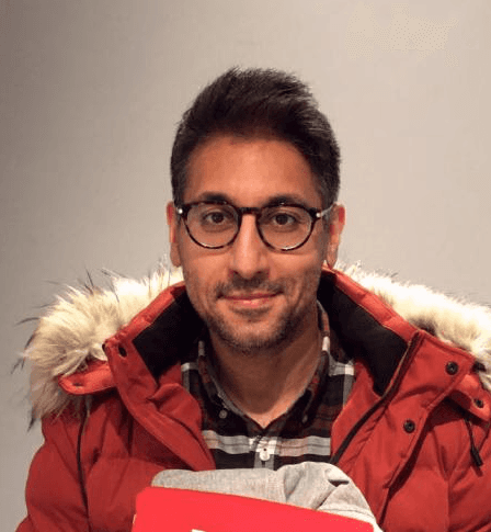 Man in red parka with fur hood and glasses