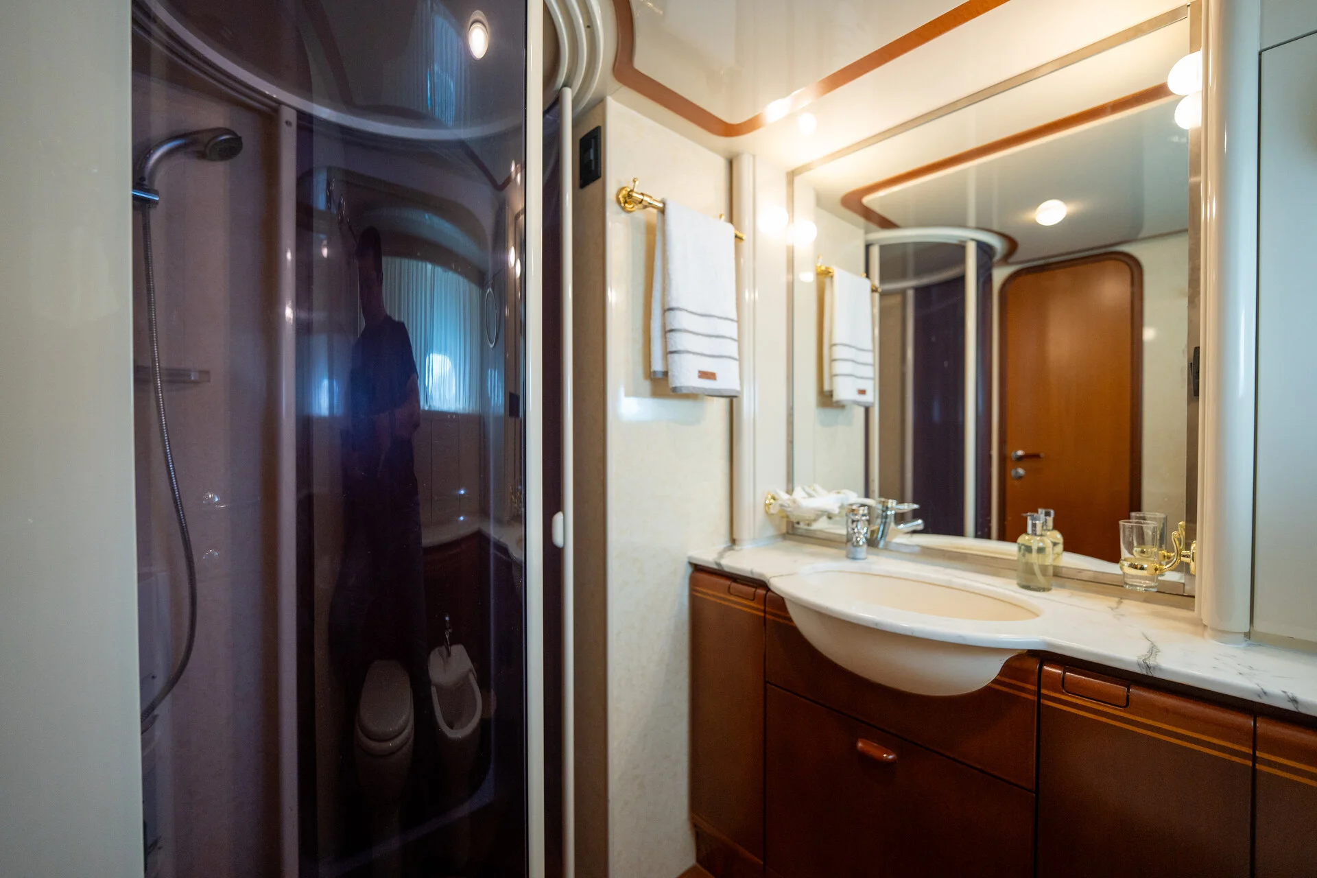 White Rock 36 speedboat with captain at helm cruising calm blue waters near Paros coastline with hills in background.
