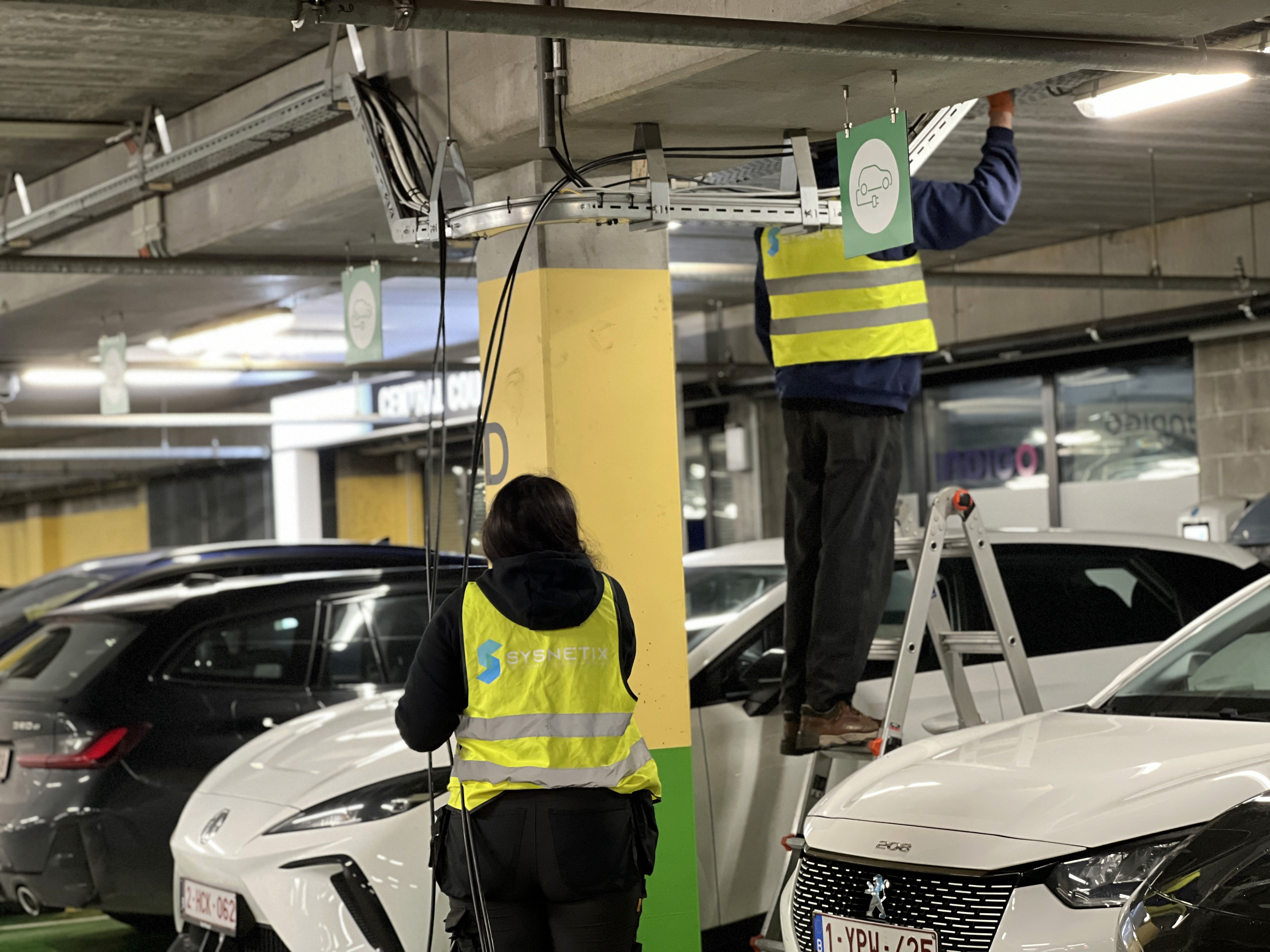 Sysnetix-technici installeren netwerkapparatuur in een parkeergarage