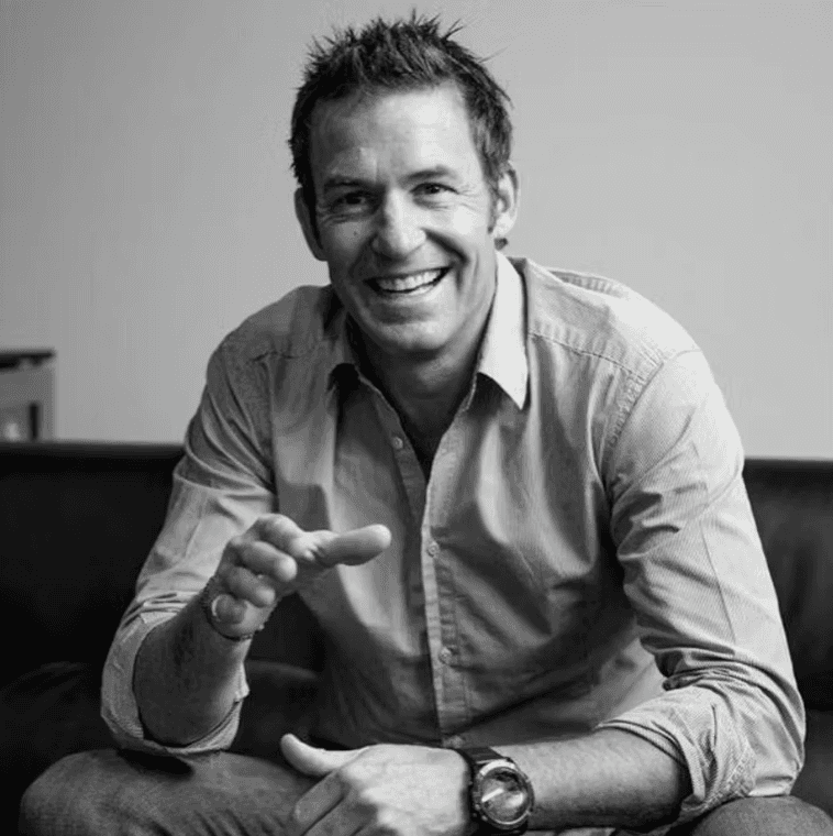 Portrait of a laughing person with curly hair wearing a white shirt