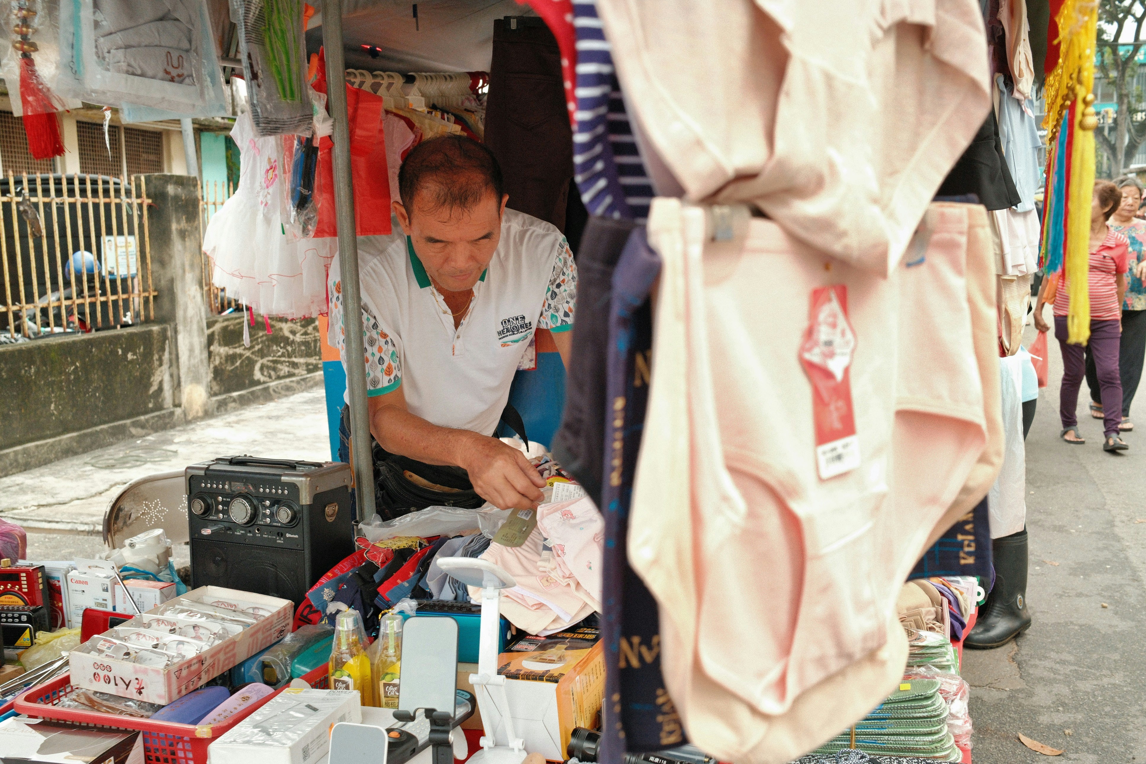 A man standing in front of a store selling items