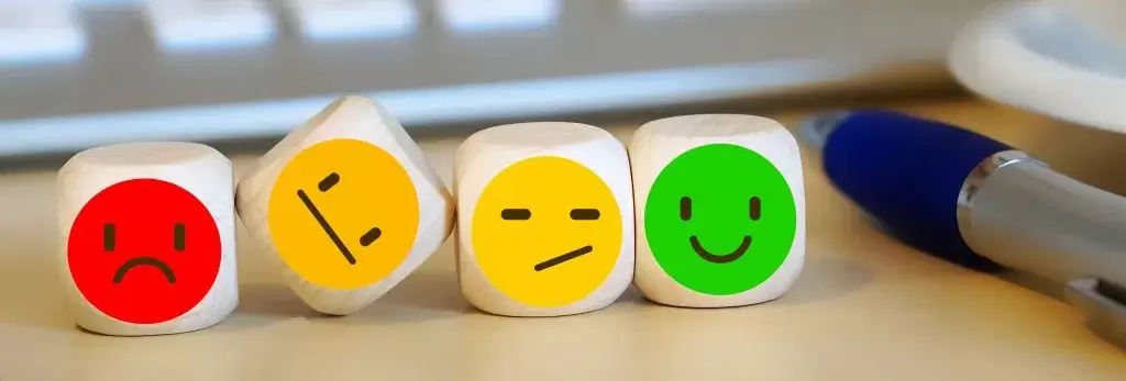 Image of 4 dice on a desk with differeing emojis on