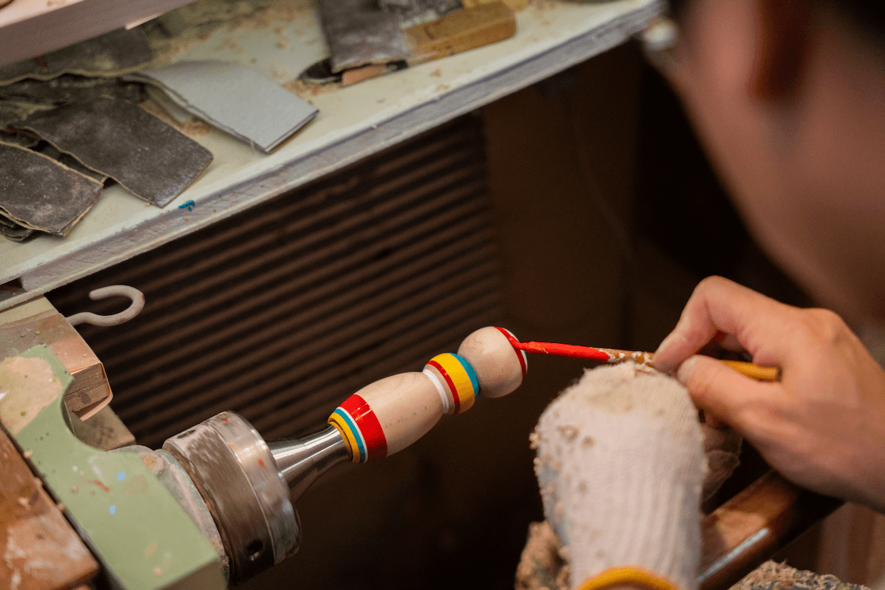 Craftsman painting kokeshi doll