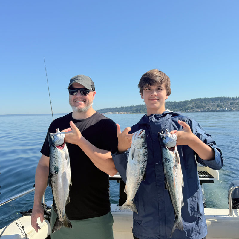 Father son holding their salmon catch
