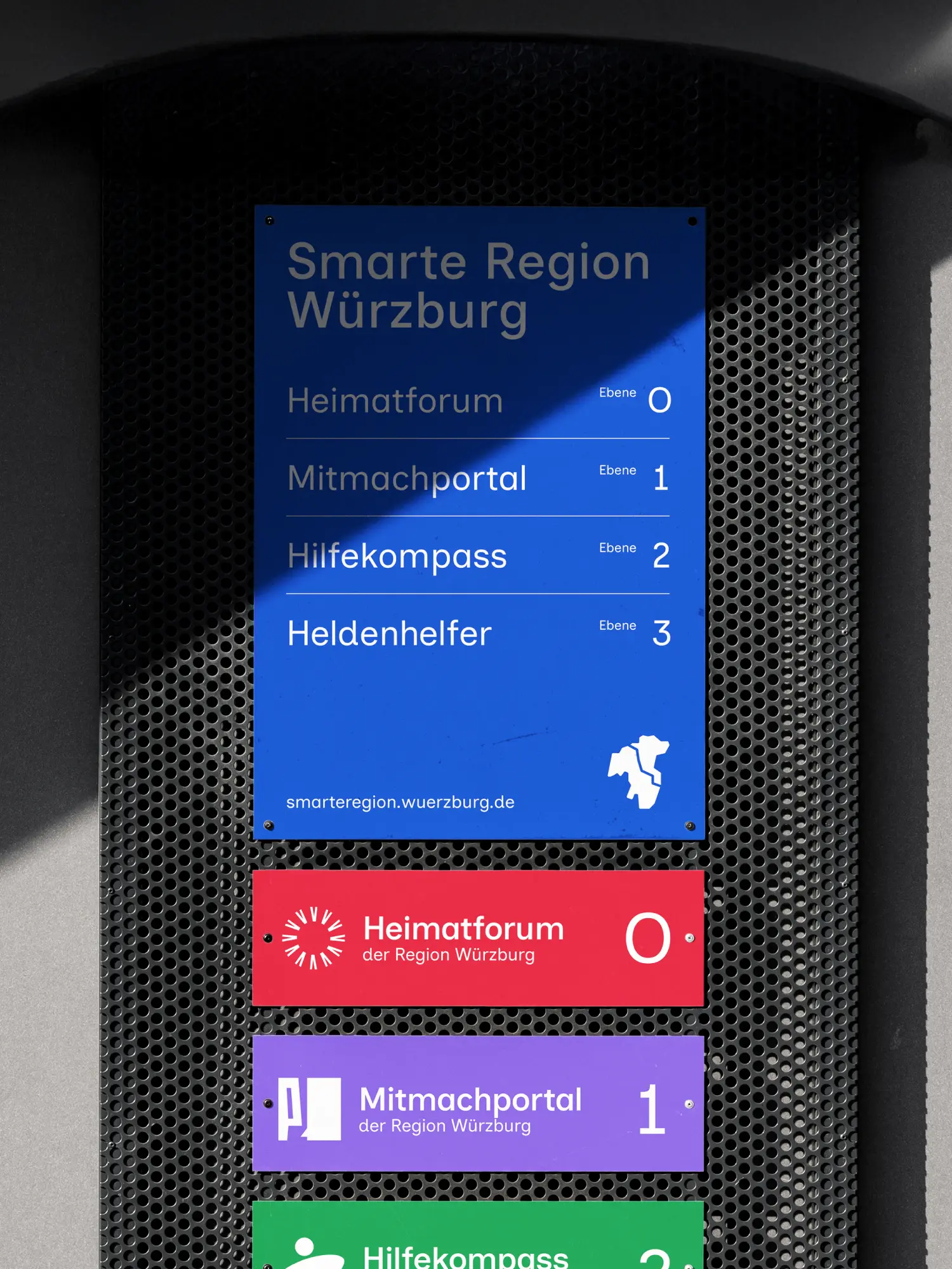 Wegweiser-Schild „Smarte Region Würzburg“ mit Ebenen zu Heimatforum, Mitmachportal, Hilfekompass und Heldenhelfer.