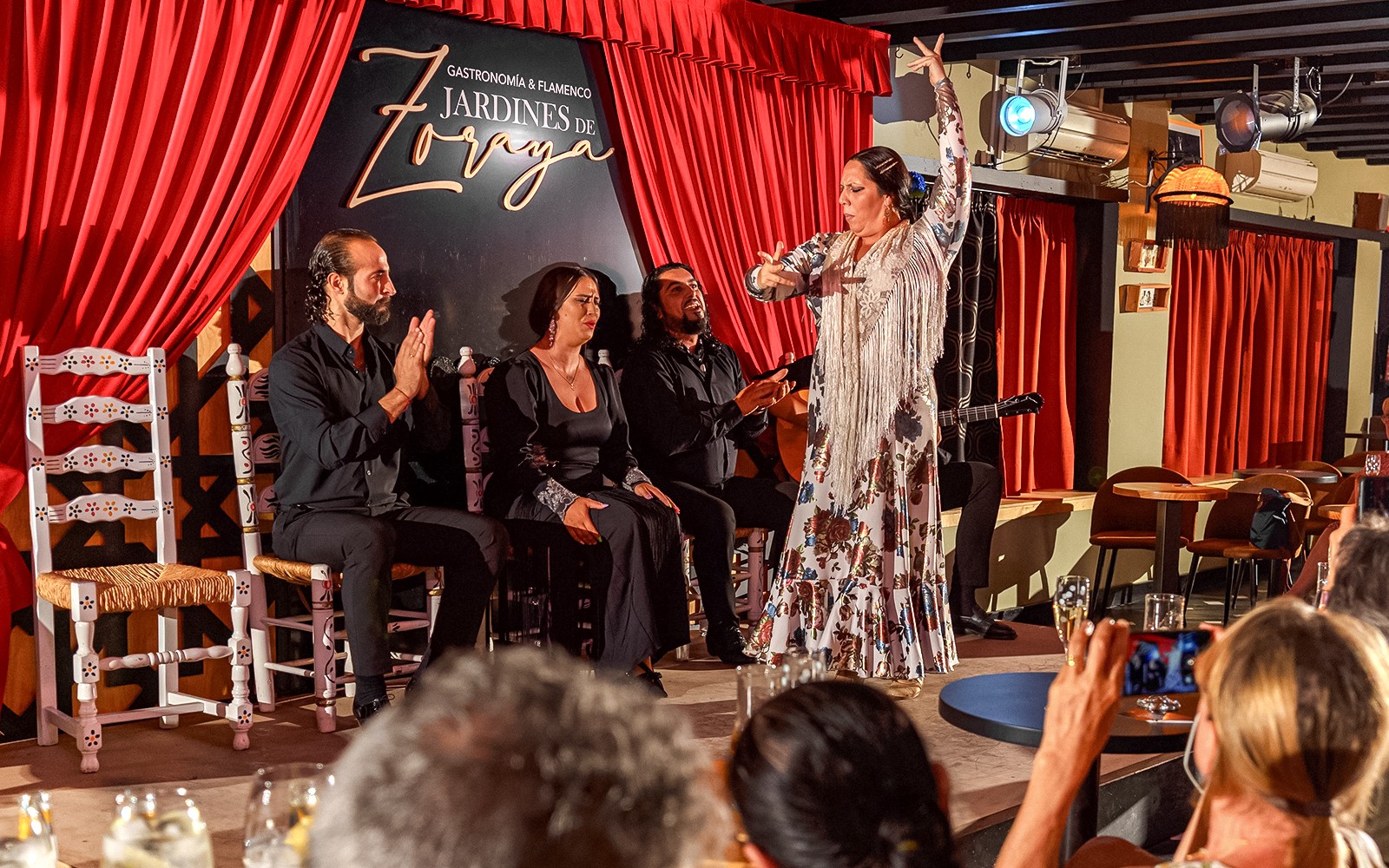 Flamenco dancer performing at Tablao Jardines de Zoraya with musicians in Granada.