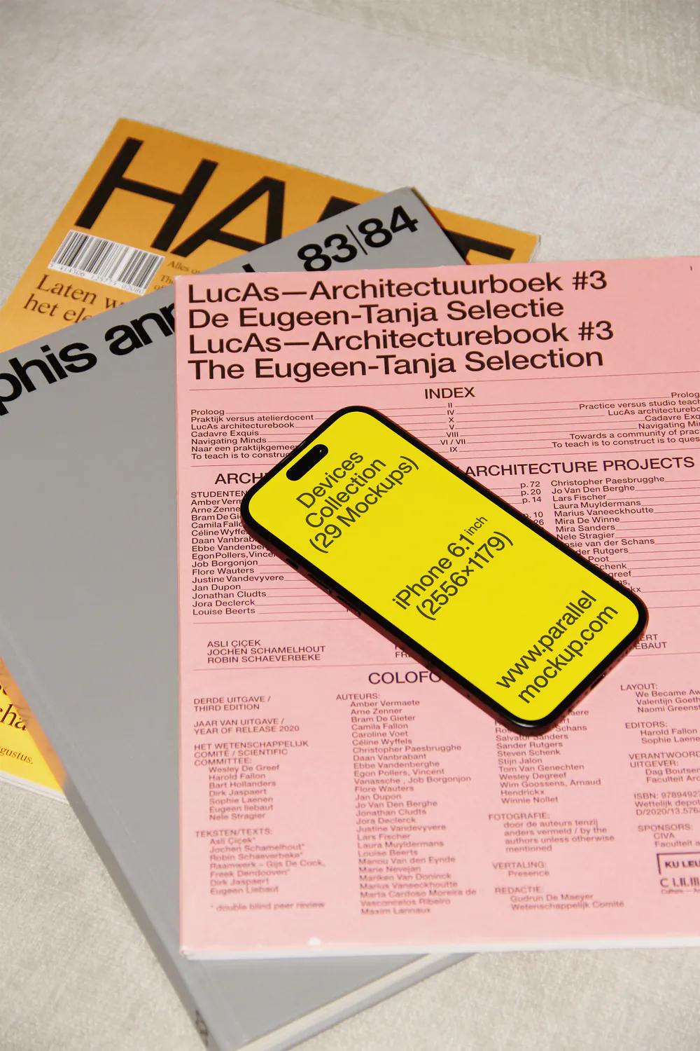 A stack of papers with various colors, featuring a yellow ticket or tag on top of a pink sheet.