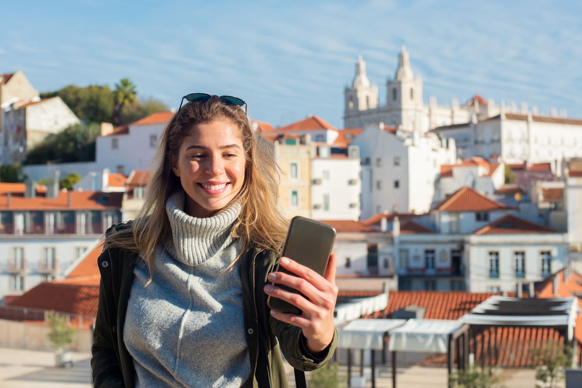Traveller using a smartphone in front of the Lisbon skyline