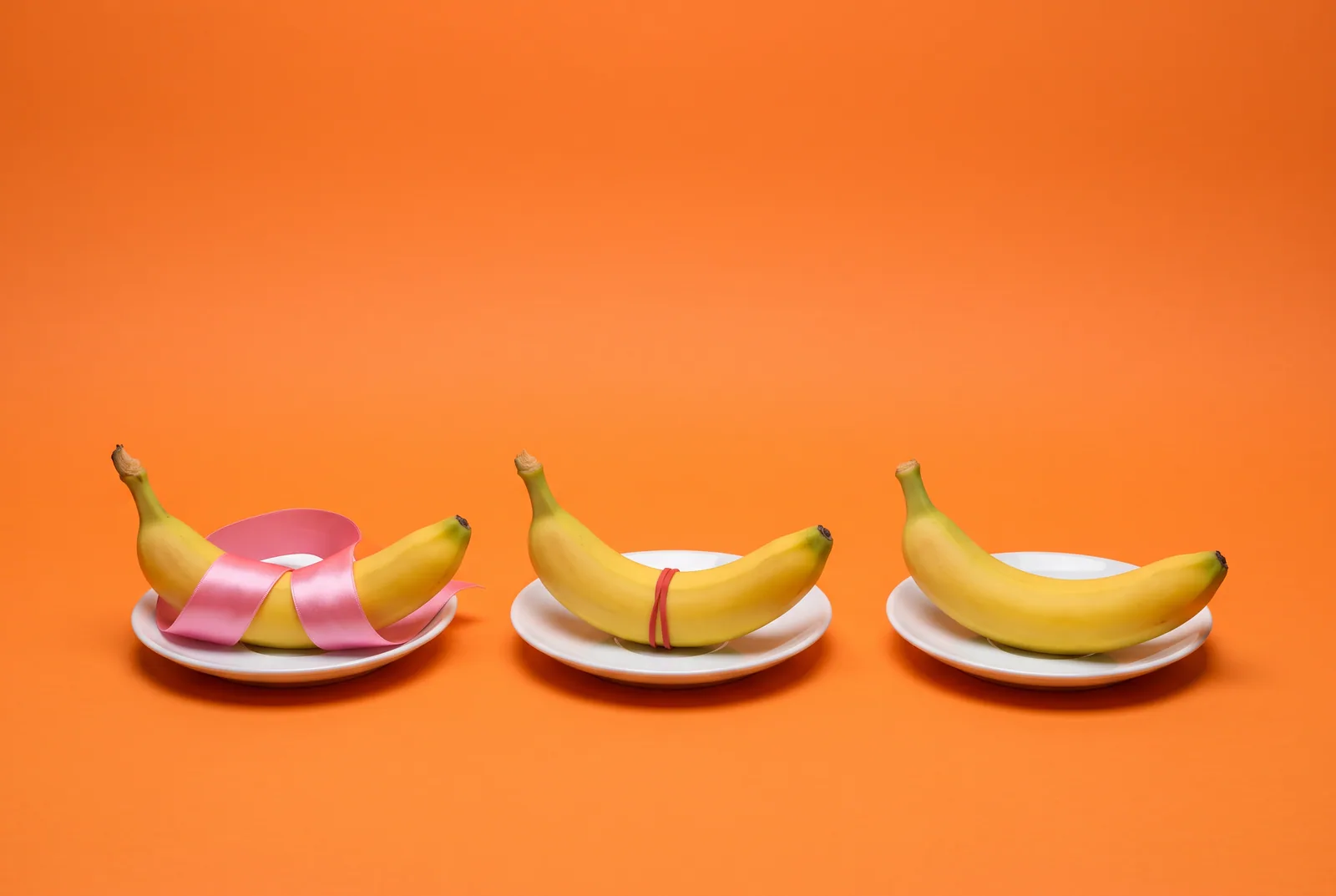 Three bananas held by a loose ribbon, a tight rubber band and nothing, telling death grip syndrome apart from other problems