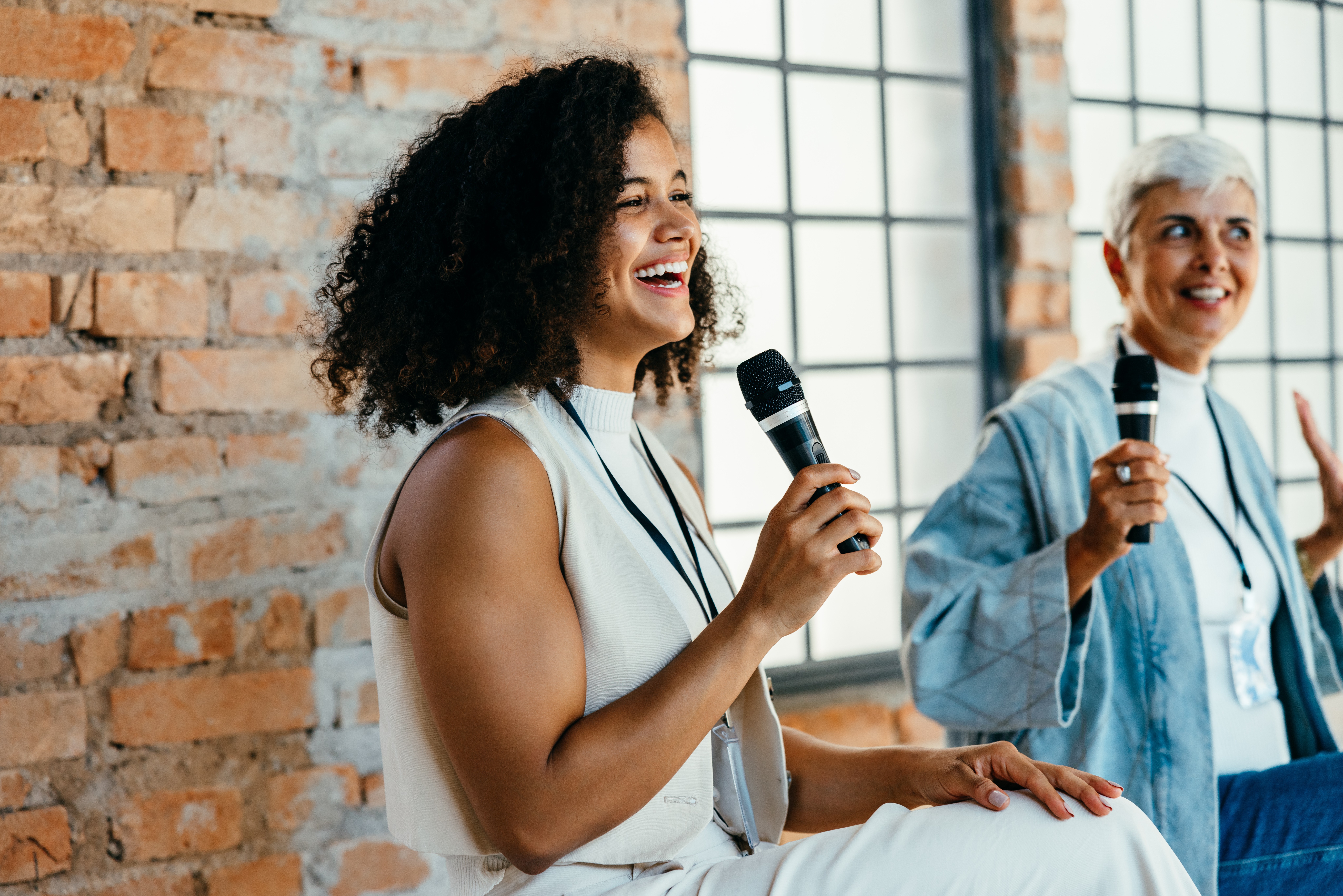 Two women with microphones presenting