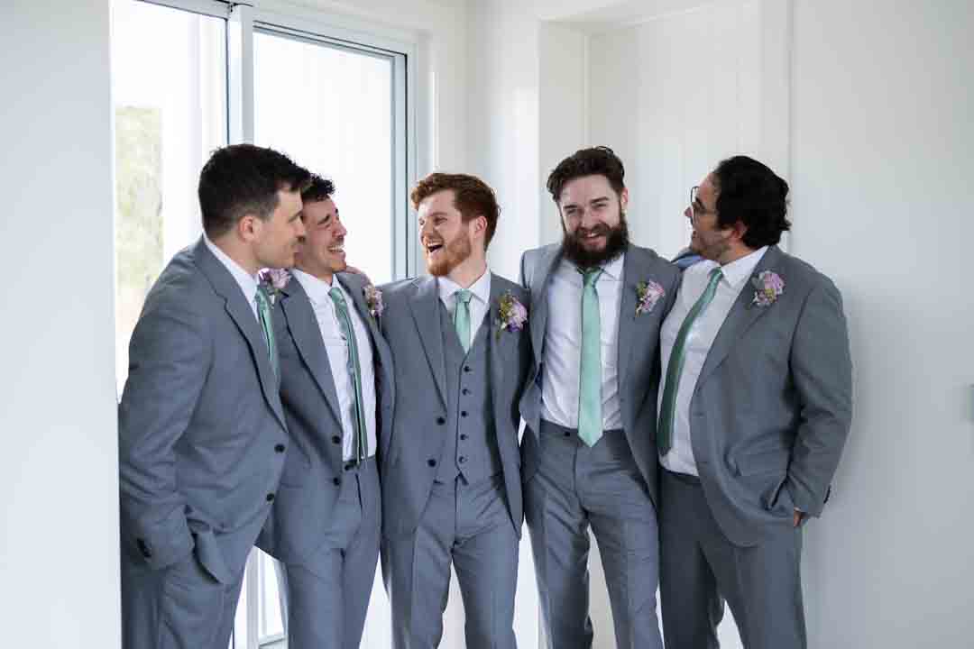 Groom and groomsmen laughing together