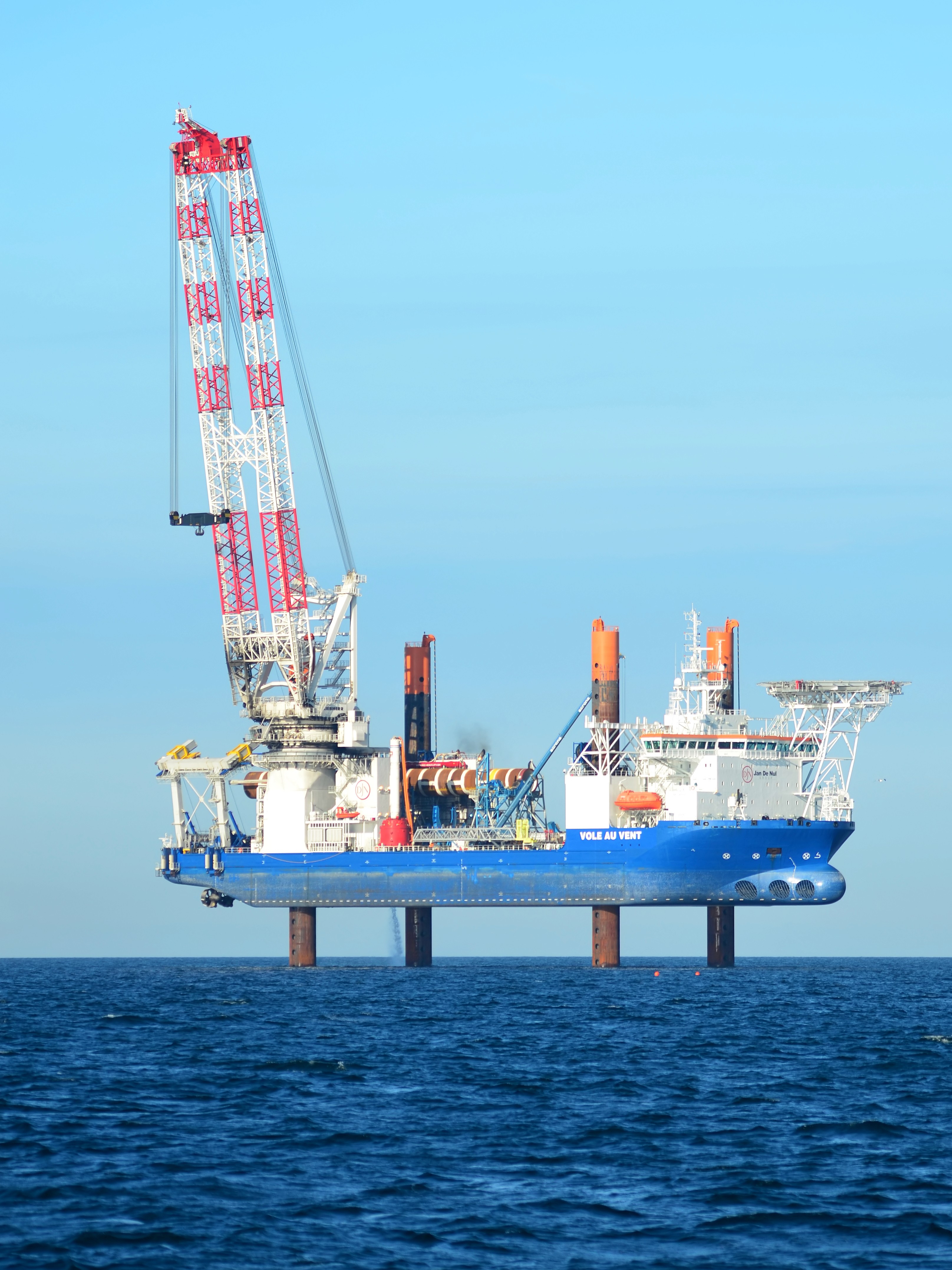 Offshore wind turbines operating in open sea under a clear blue sky.