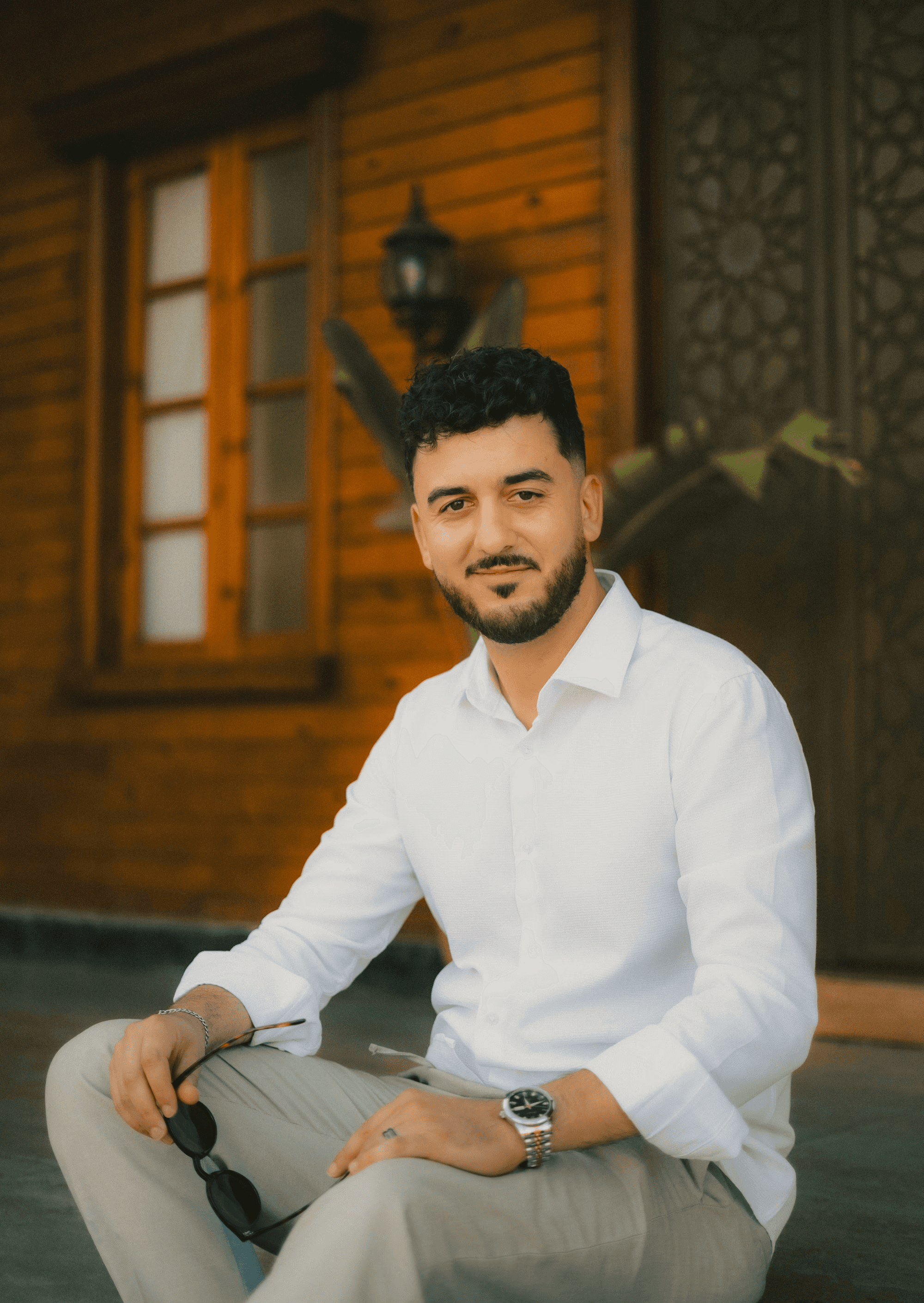 Two women sitting together in a cozy, well-lit workspace, smiling and collaborating over a laptop, with a coffee cup and a bowl on the table.