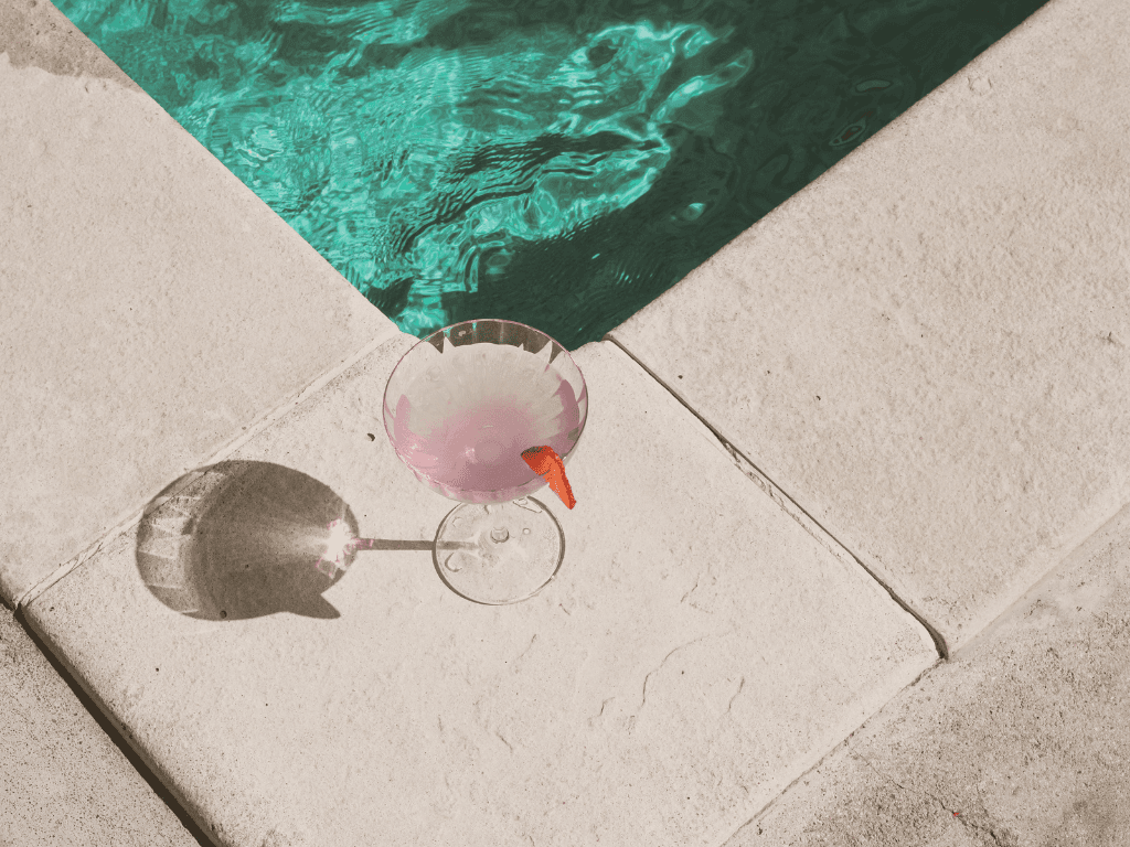 Poolside lifestyle scene with cocktail glass and water reflections for LALU Hospitality hero image