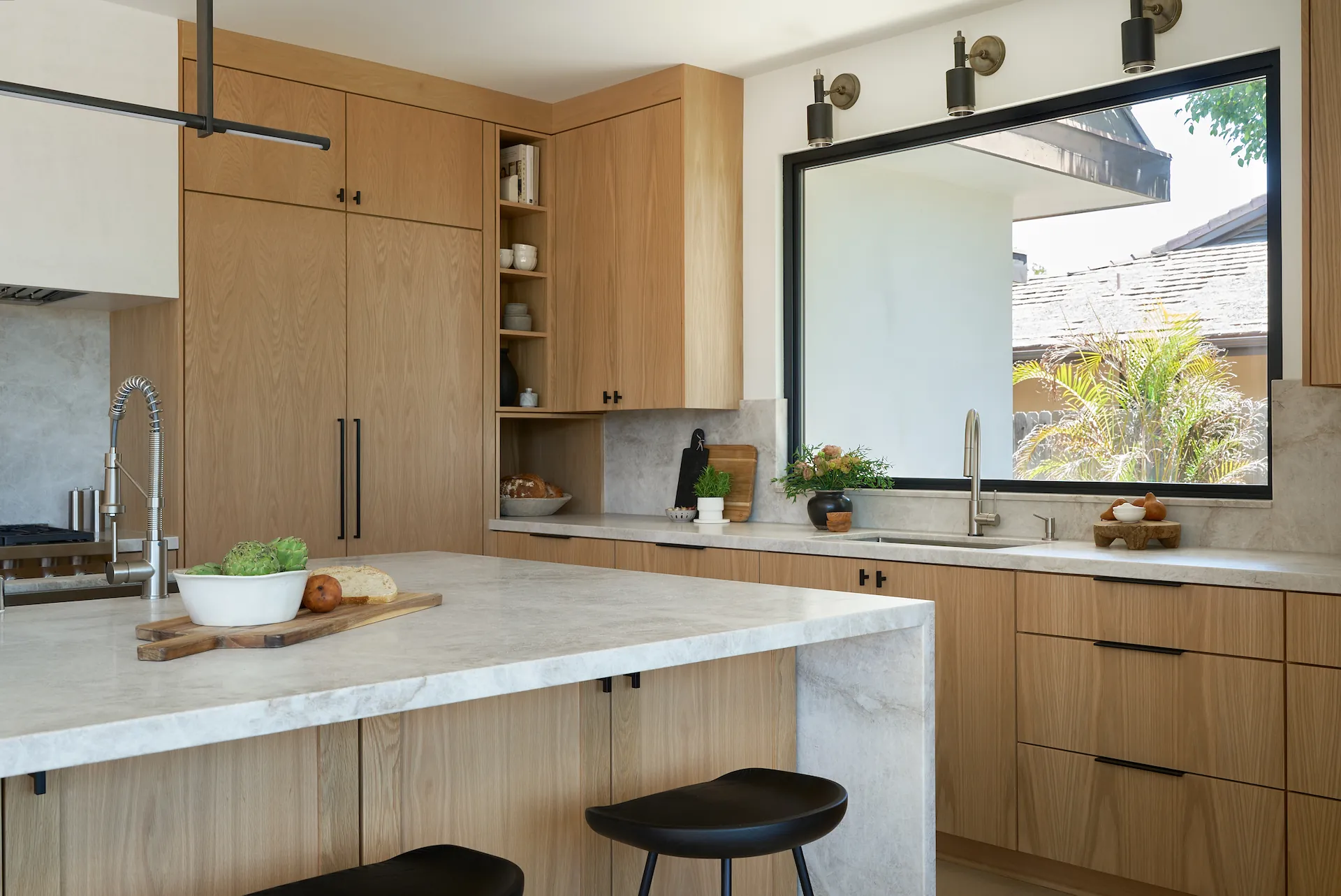 Alternate angle view of the Fullerton kitchen, showcasing the island and main sink wall with large picture window. Photo by Todd Huge.