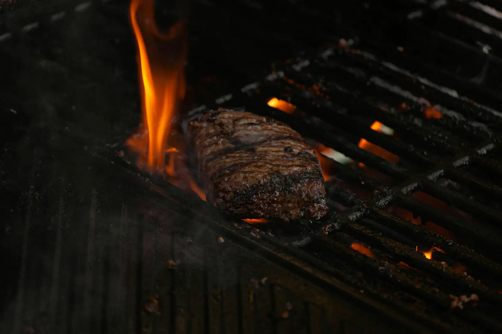 Steak grilling over an open flame.