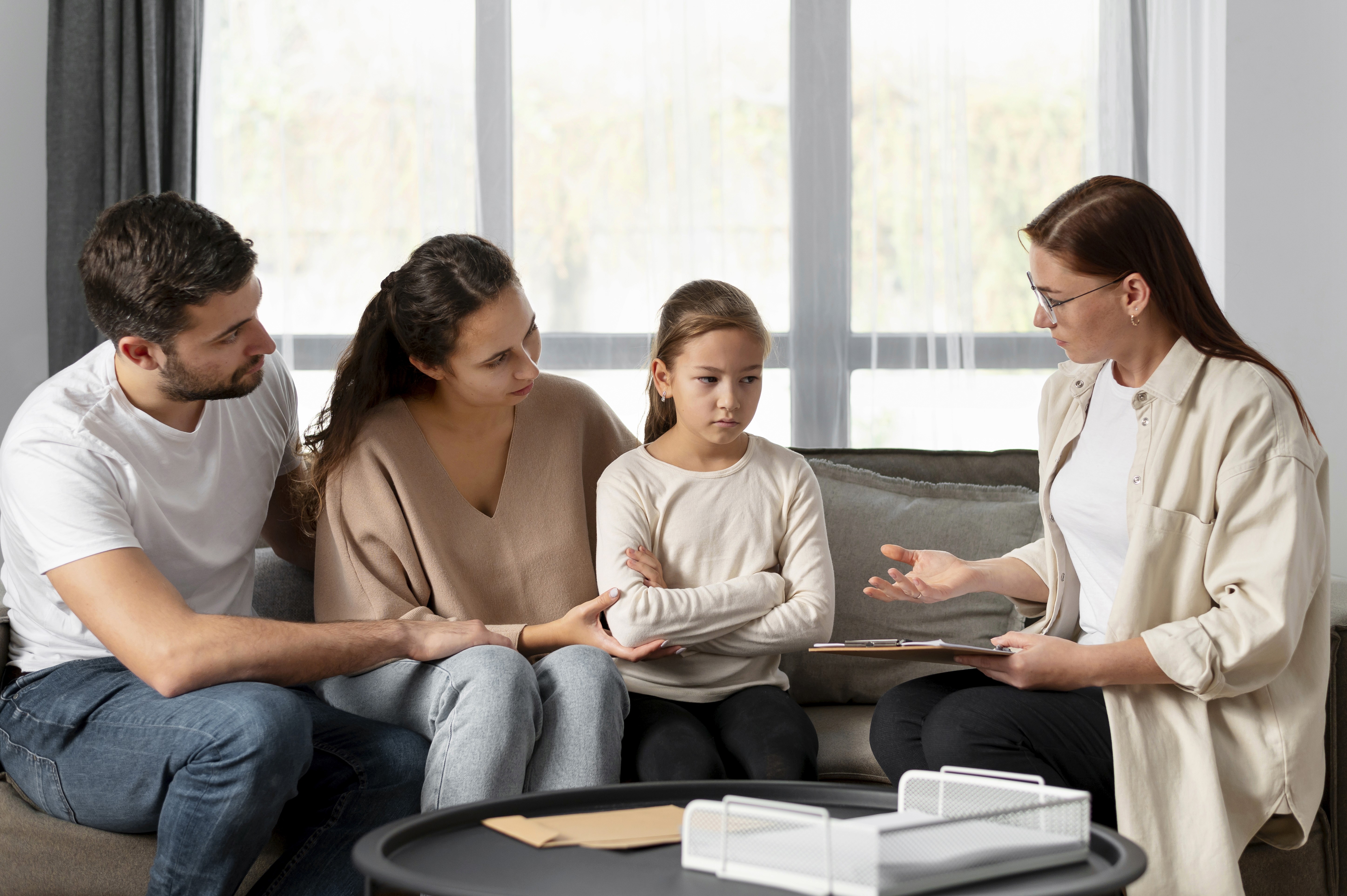 A kid and her parents during a family counseling session.