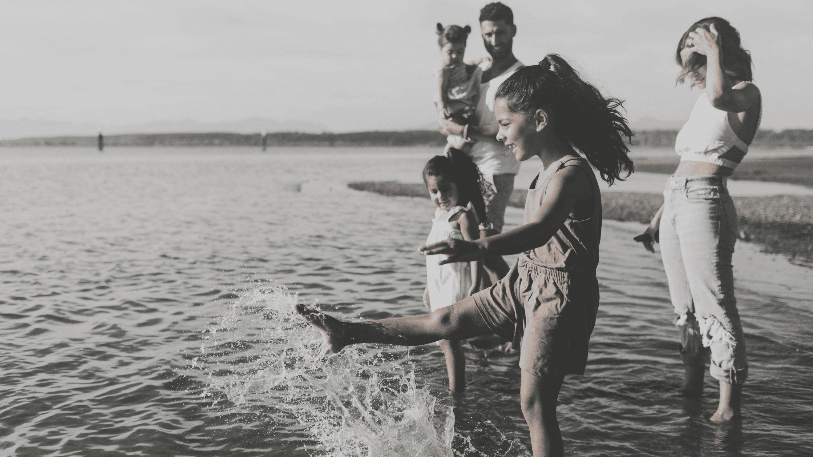 A photo of a family on the beach playing in the water