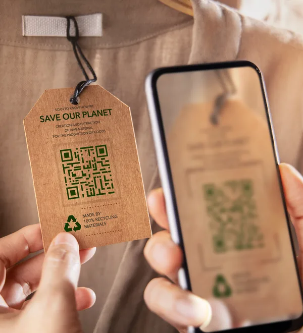 Smartphone scanning the QR code on a garment hang tag to see product details