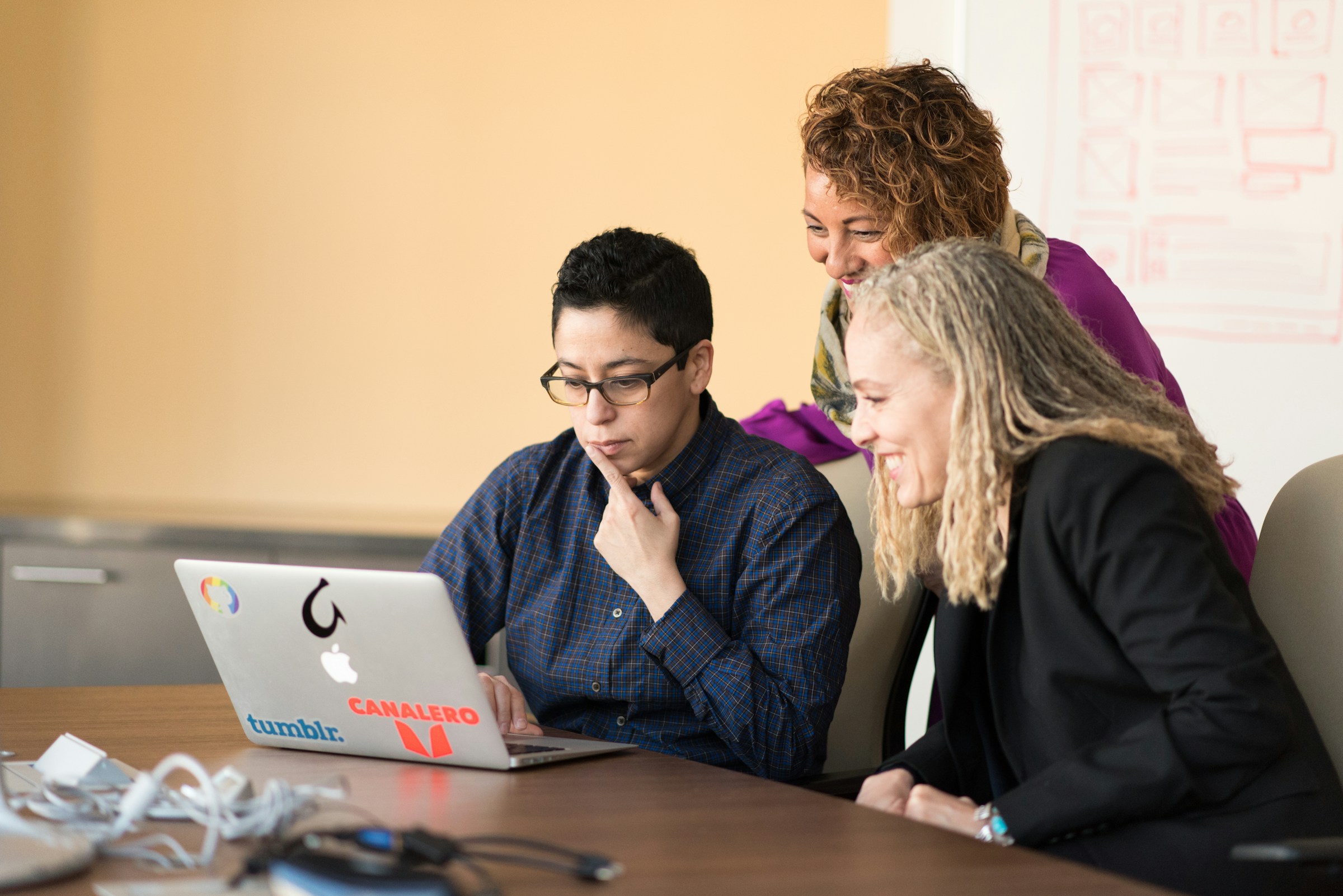 woman infront of laptop with team - How to Write Discussion in Research Paper