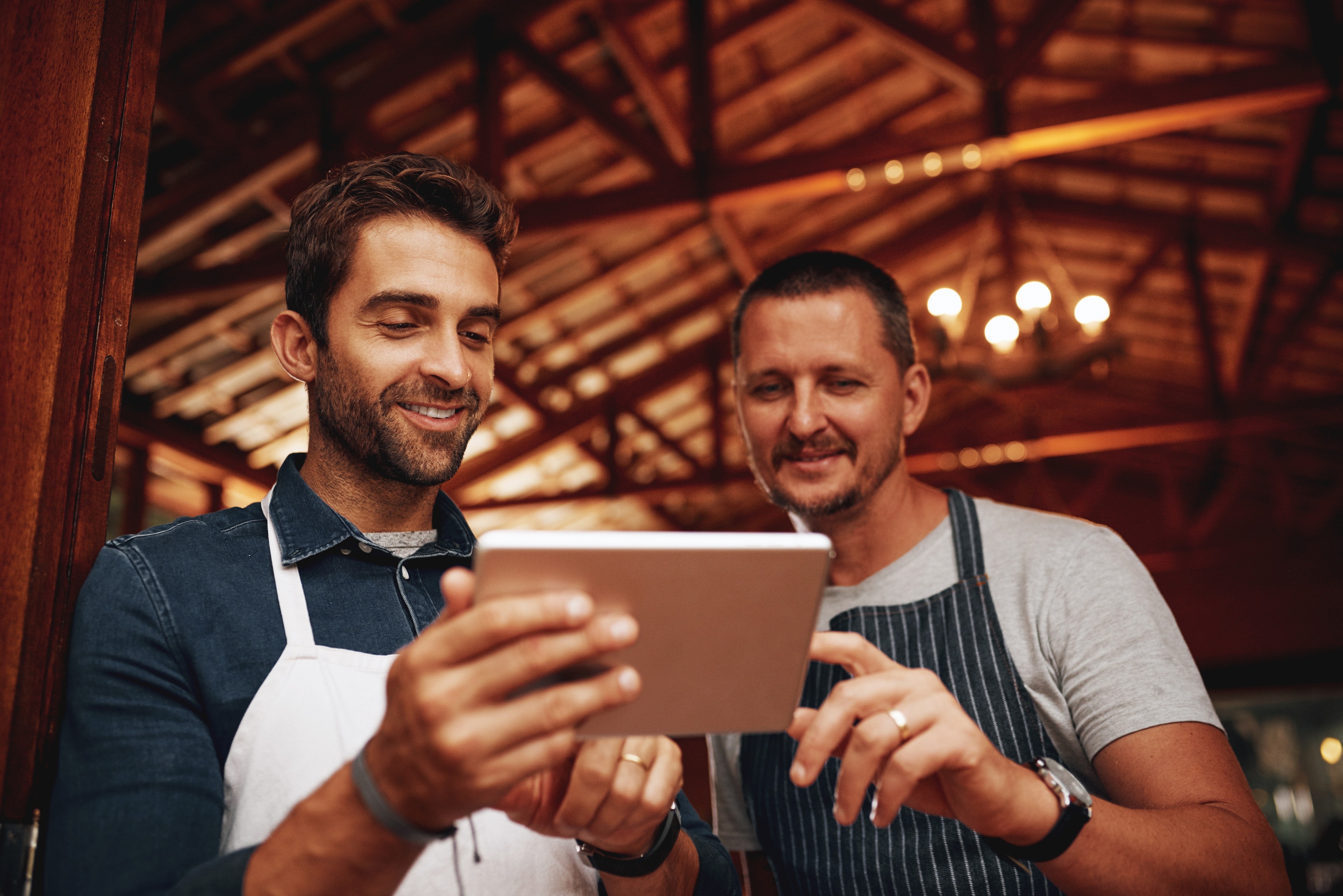 business owners working together looking at tablet screen