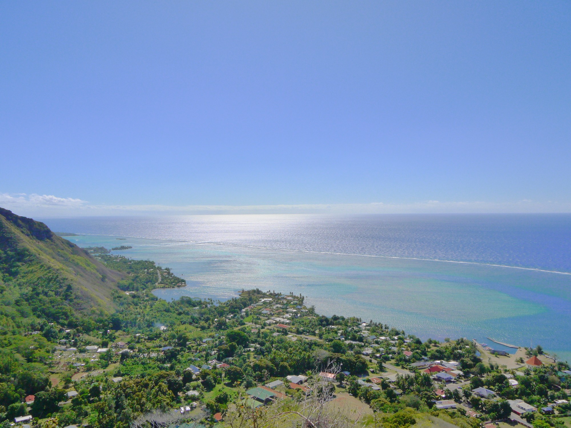 a street lined with stone buildings next to a lush green forest
