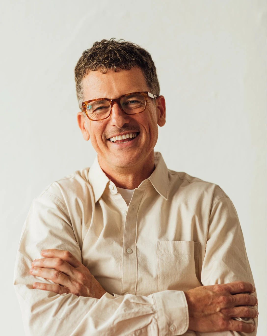 Artistic portrait of a person with translucent glasses and a white pleated top, featuring a blurred, motion-like effect for a surreal vibe.