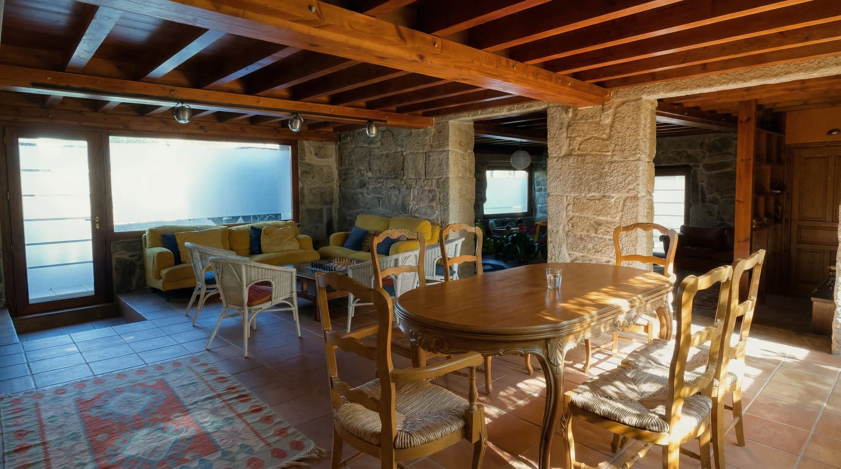 Salón comedor de Casa Cruceiro con vigas de madera y paredes de piedra - Arbo, Pontevedra