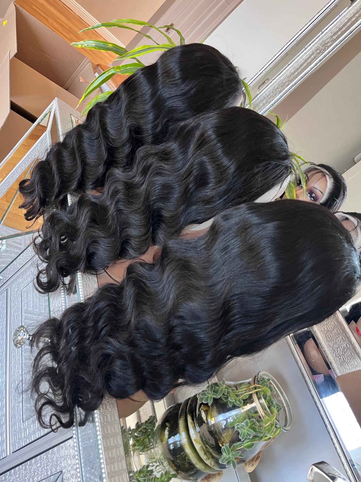 Glossy black wig styled with soft waves for a client consultation