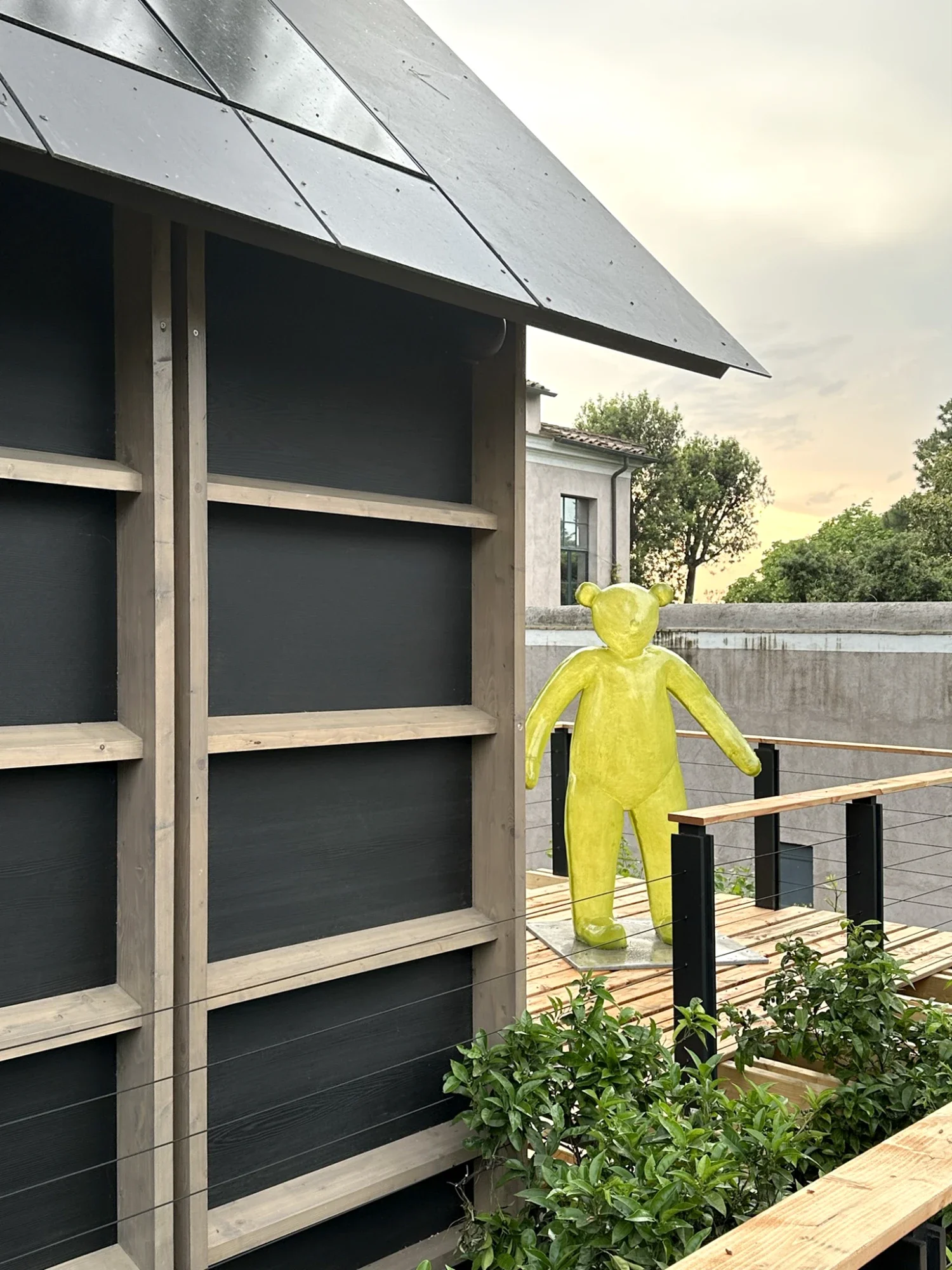Terrasse de l'écolodge Villa Médicis avec sculpture jaune et bardage bois