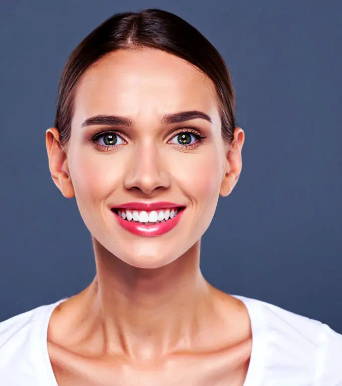 Young woman smiling showing white, healthy teeth. White shirt.