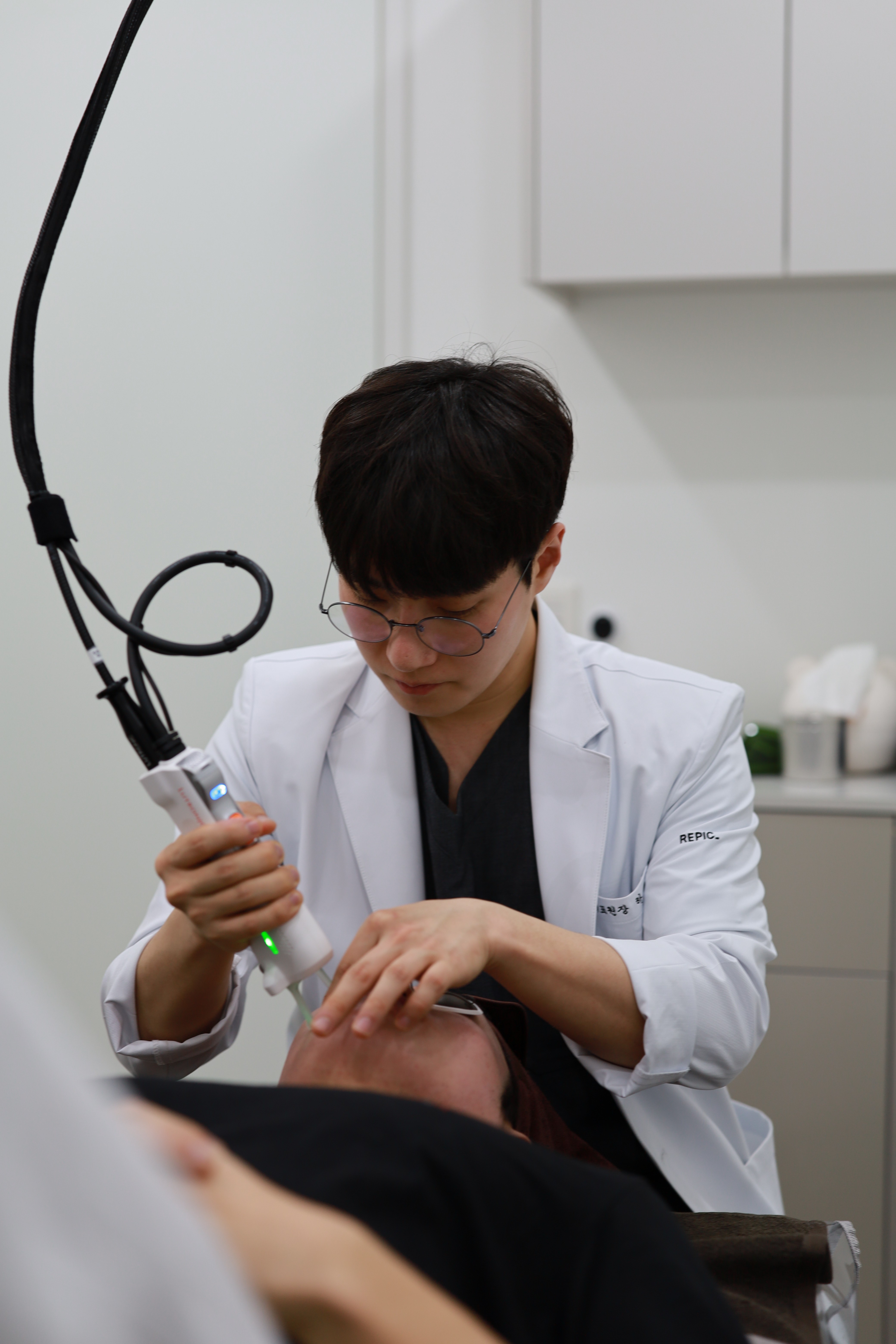 Dr. Yong-Heon Ha performing laser treatment on a patient