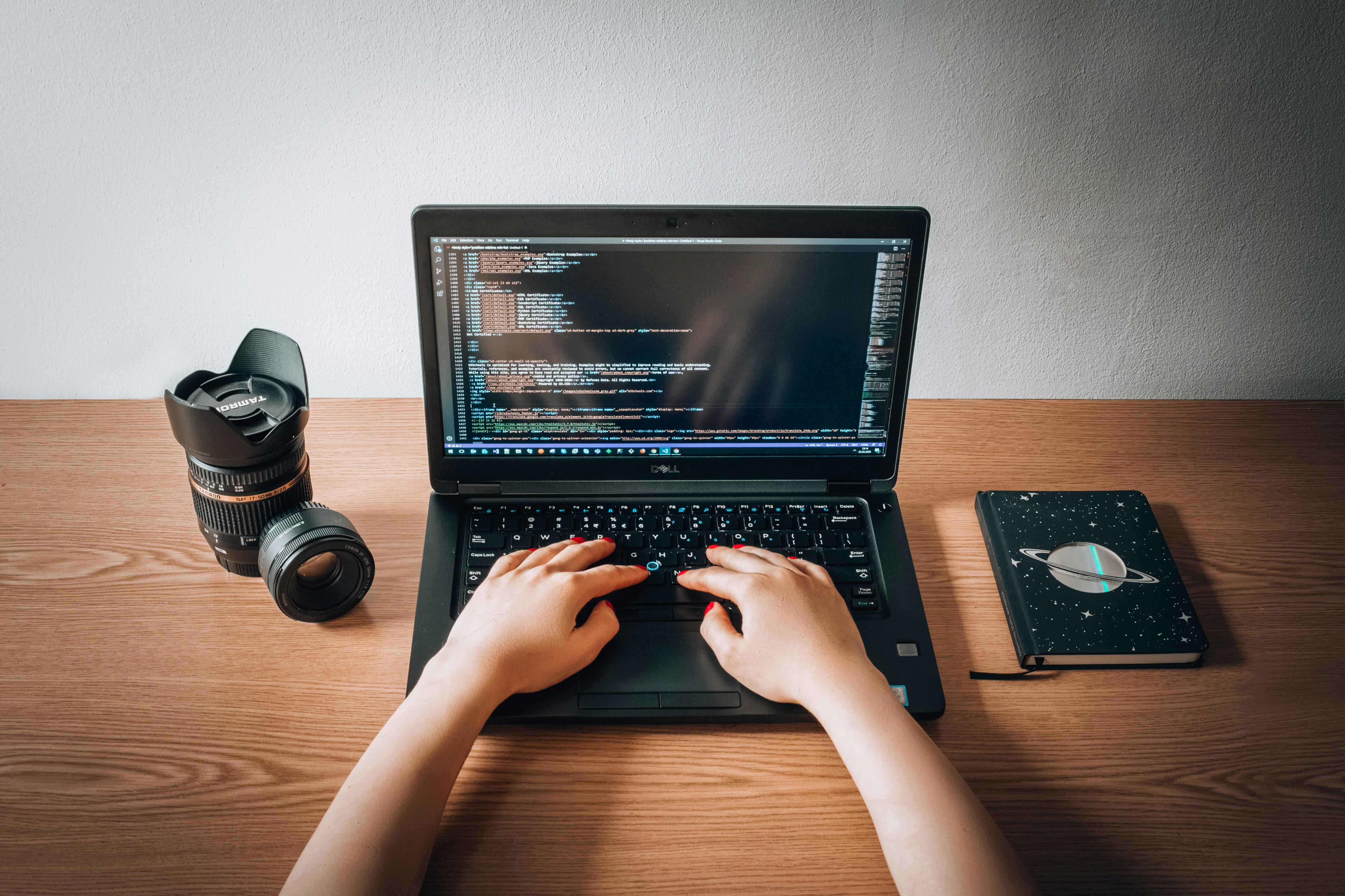 Person working calmly at a desk with a laptop, notebook, and minimal workspace setup