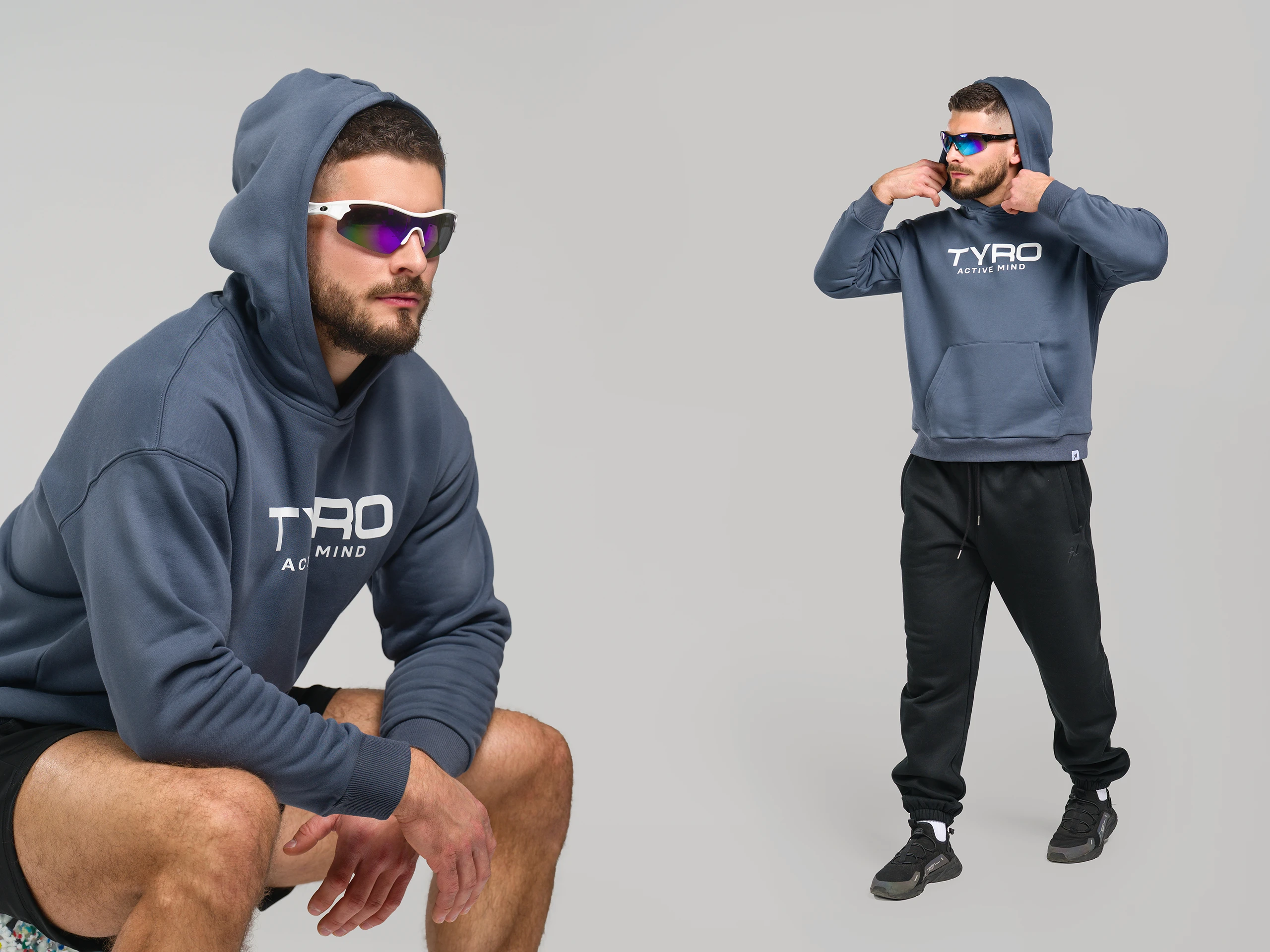 Person wearing a blue hoodie and sporty sunglasses posing in a studio setting.