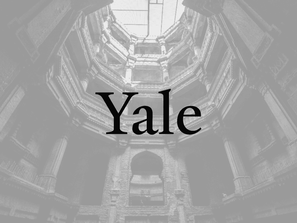 brown wooden staircase in between brown concrete walls