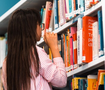 aluna conferindo livros na biblioteca