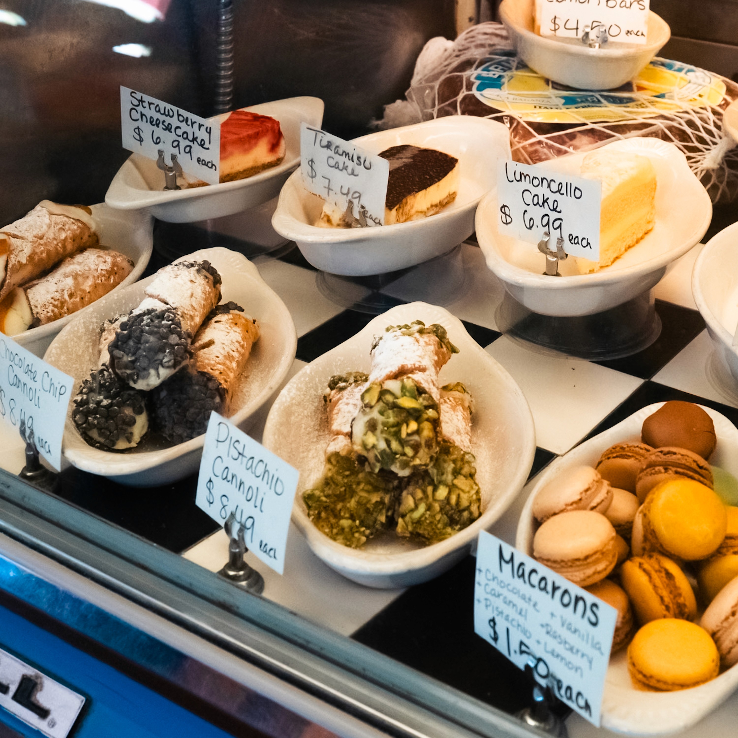 Deli case with antipasti, pesto, prepared salads and macarons at Sampino's