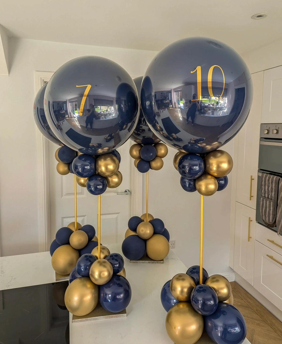 Trio of navy and gold balloons with transparent tops labelled with the numbers 7 and 10