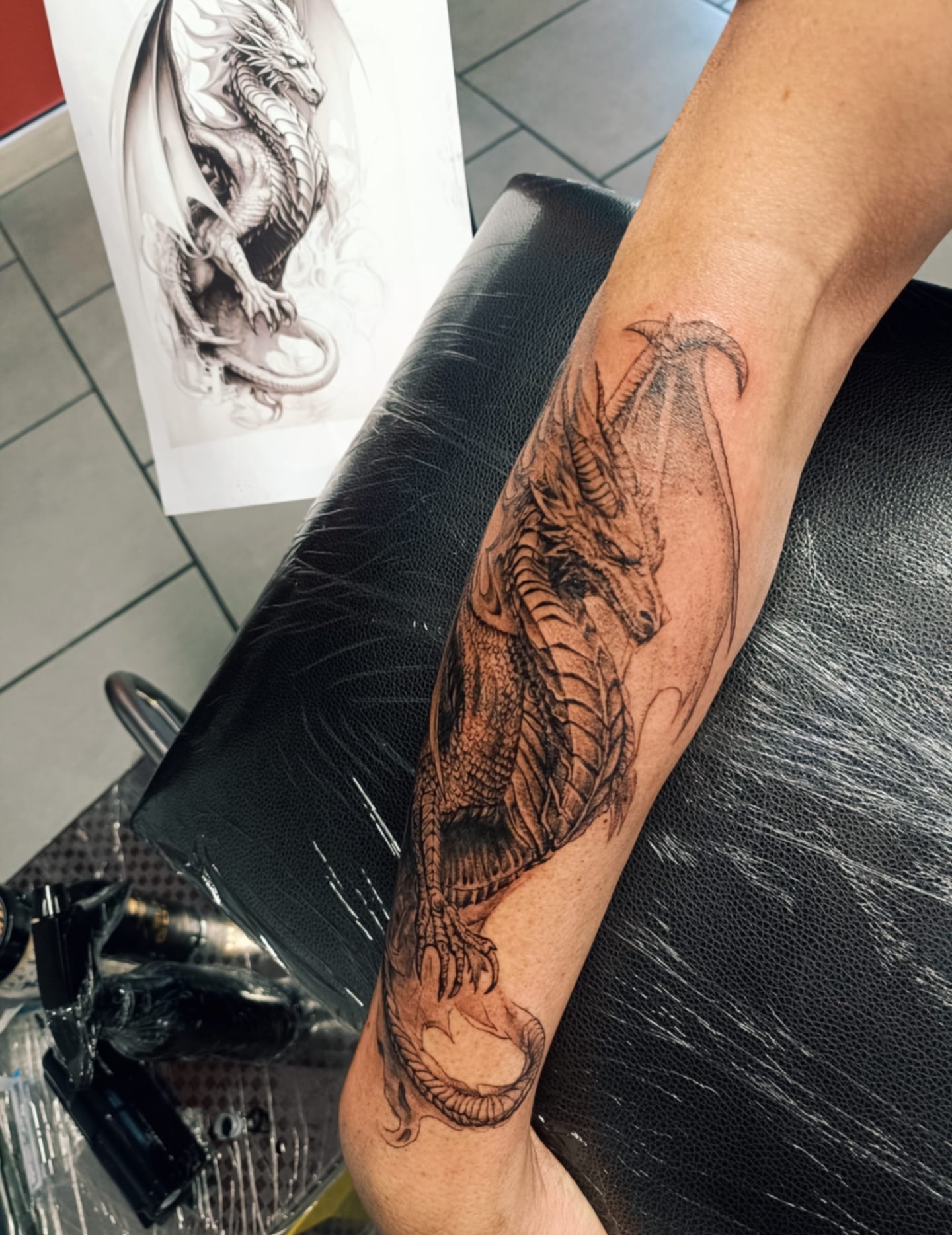 tatouage dragon en noir sur l'avant bras pour homme