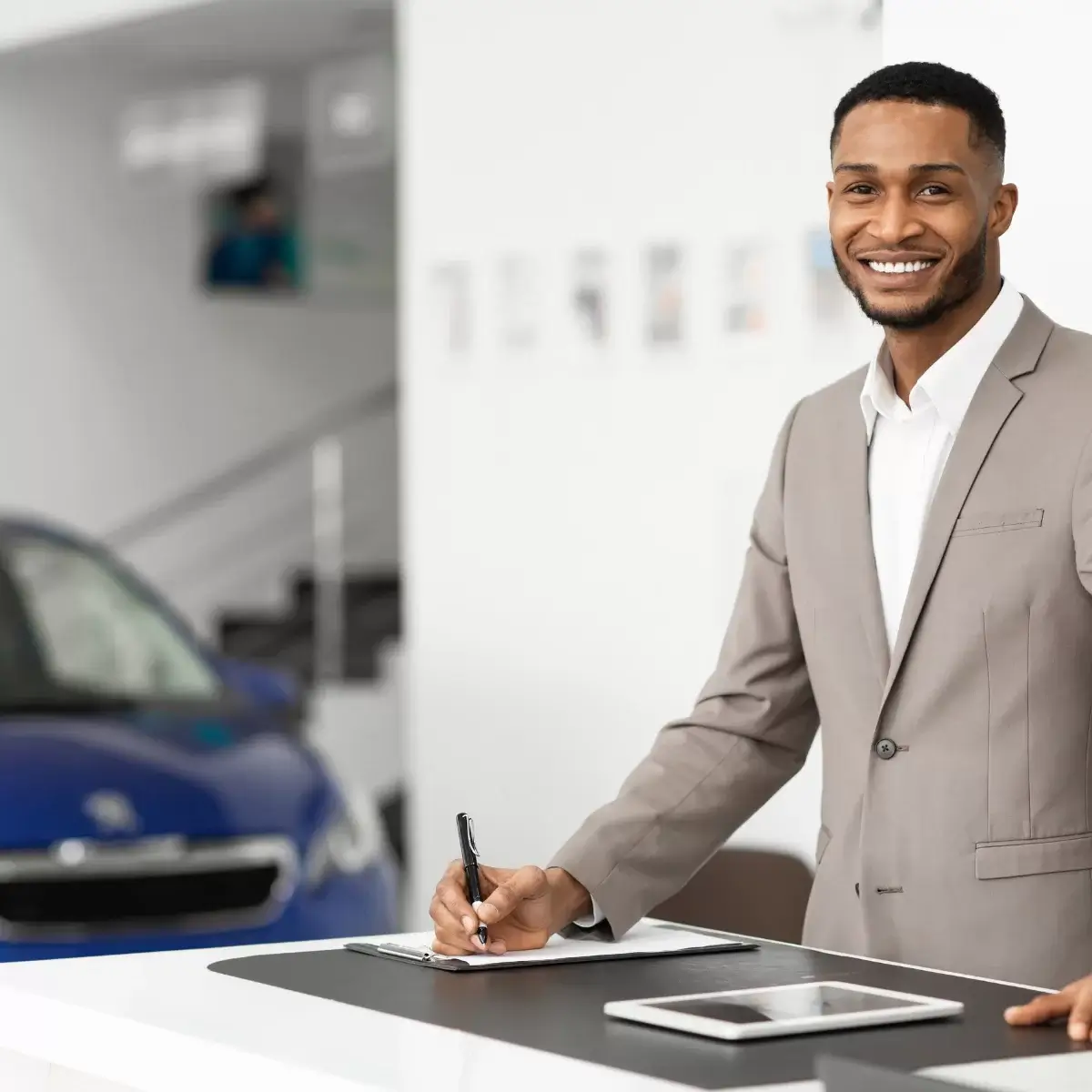 Image of a man smiling whilst signing a paper