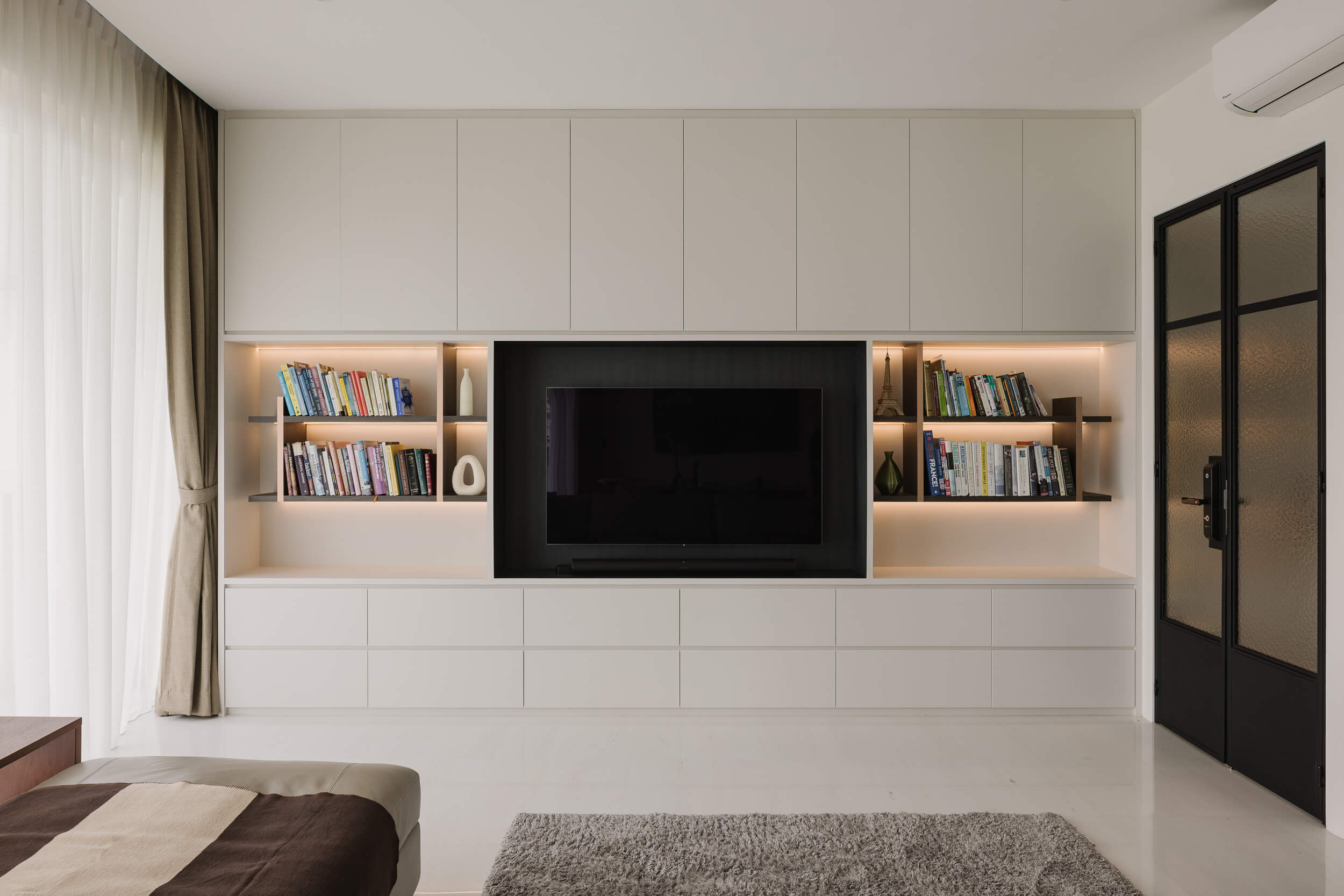 Modern bathroom featuring wooden cabinetry, a bathtub, a sleek sink, and natural light from a window.